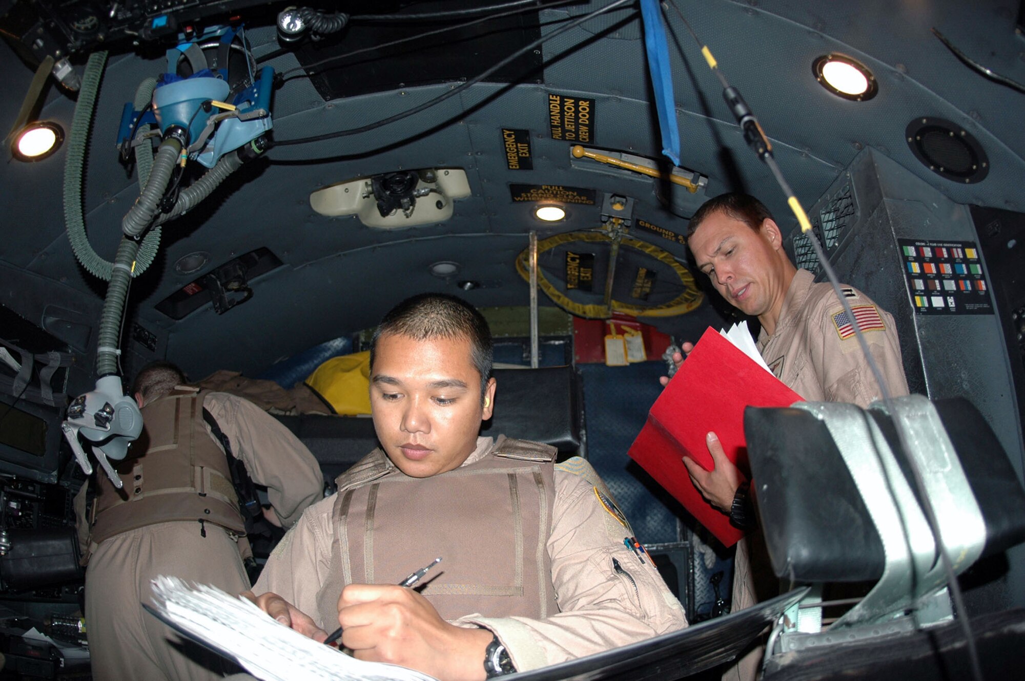 Staff Sgt. Adonis Del Rosario (left) and Capt. Brett Cochran review the play book one last time prior to departing Kandahar International Airport, Afghanistan, for an airdrop July 22 over the Helmand Province. The squadron successfully met their objective of dropping 120,000 leaflets over the Helmand Province, prepping the battlefield. Sergeant Del Rosario is a 746th Expeditionary Airlift Squadron mission flight engineer, and Captain Cochran is a 746th EAS C-130 Hercules pilot. (U.S. Air Force photo/Capt. Teresa Sullivan)
