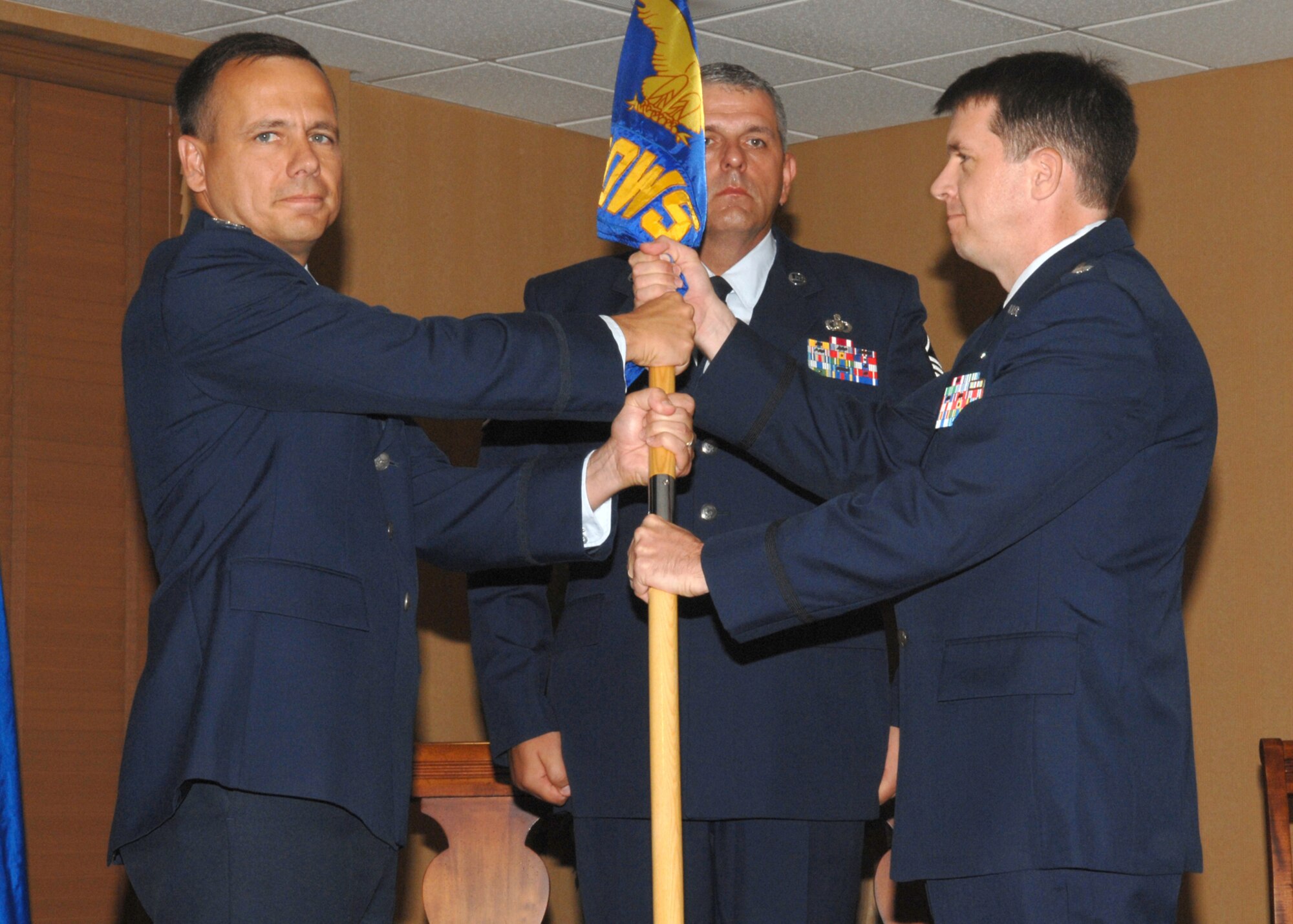 Lt. Col. Donald G. Shannon receives the 25th Operational Weather Squadron guidon from Col.Thomas B. Frooninckx during a change-of-command ceremony held at the Mirage Officers’ Club here on July 17. Colonel Shannon was previously the deputy chief of the Operations Weather Division of the Air, Space and Information Operations Directorate, Headquarters Air Force Special Operations Command.  (U.S. Air Force photo/Airman 1st Class Alesia Goosic)