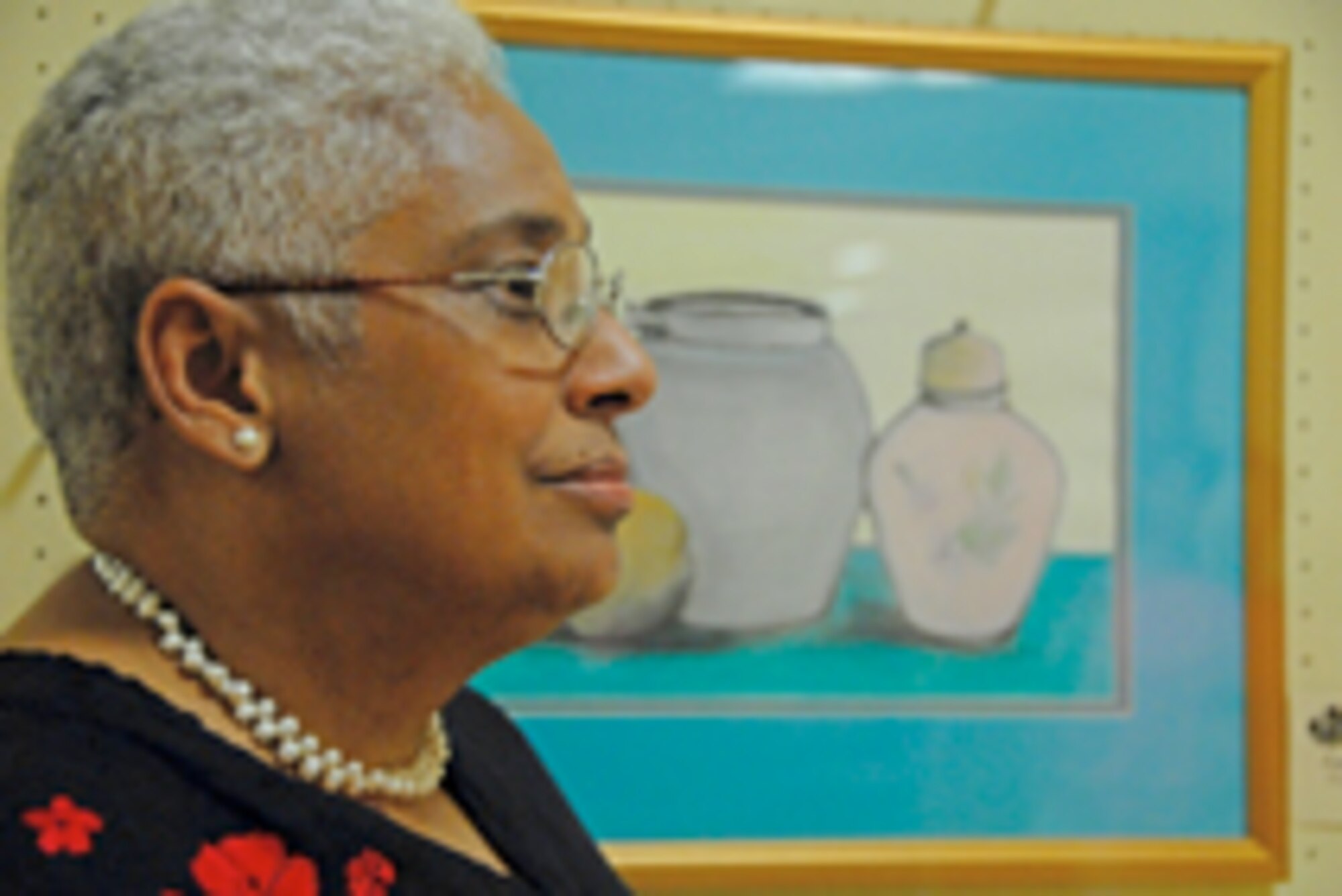 Artist Cynthia Ferguson, of the Wright Patterson Air Force Base Officers Wives Club, displays her painting entitled "Tranquility" July 18 at an exhibit hosted by the club in the Dayton Public Library downtown branch. (Air Force photo/Christy Webb)
