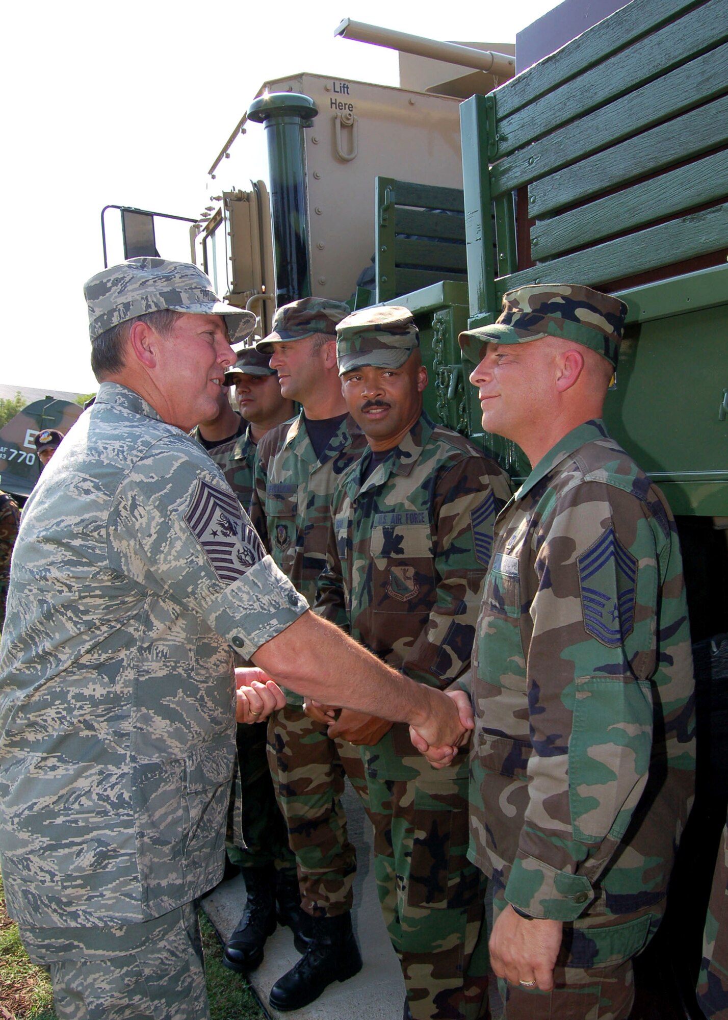 Chief Master Sgt. of the Air Force Rodney J. McKinley coins Chief Master Sgt. Tony Killion, Air Force careerfield manager for vehicle operations at the Pentagon, following the ceremony July 23 to dedicate an Air Force gun truck to the Air Force Enlisted Heritage Hall at Maxwell Air Force Base's Gunter Annex, Ala.  The truck was decommissioned after an Improvised Explosive Device (IED) attack in Iraq that made the vehicle inoperable.  Both chiefs are currently attending the Senior Enlisted Leader Summit. Chief Killion was recognized for prior convoy duty in Iraq.  (U.S. Air Force photo/Master Sgt. Lee Roberts)
