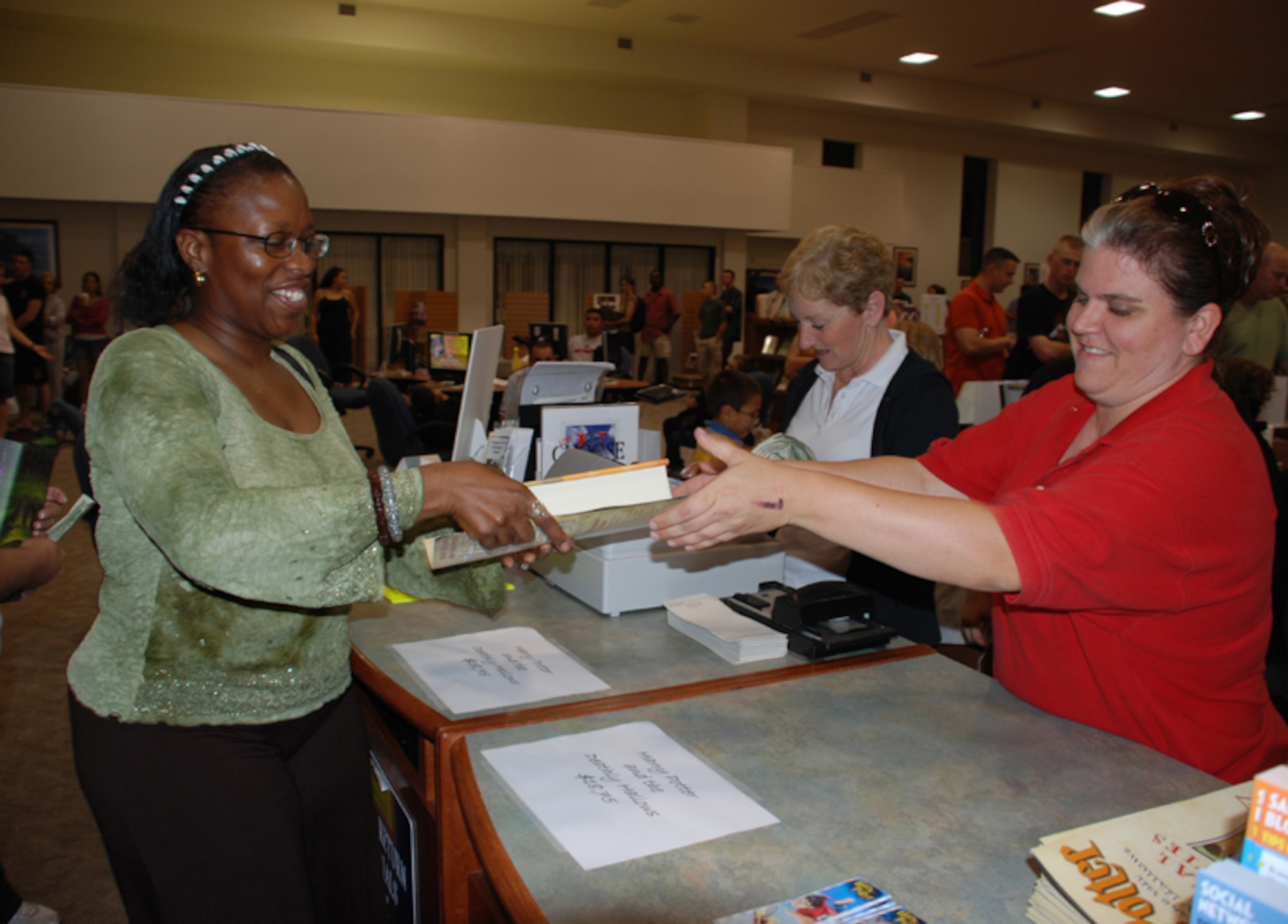 Tech Sgt. Jacqueline Harris-Smith, 366th Training Squadron, recieves her copy of Harry Potter July 20 at the Sheppard Library's Harry Potter release event. The Army Air Force Exchange Service was on hand to sell the copies one minute after midnight on July 21. (U.S. Air Force photo/Airman 1st Class Jacob Corbin)