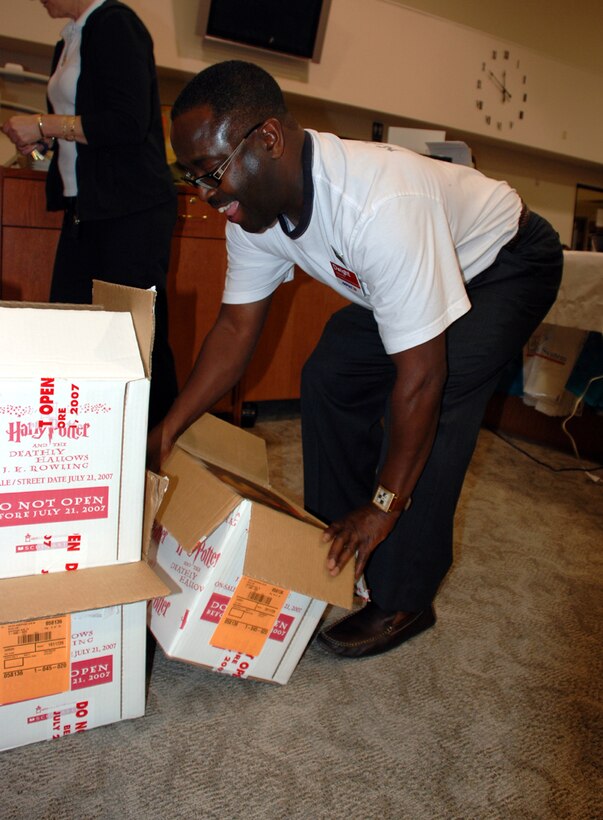 Dwight Marcus, a general manager with the Army Air Force Exchange Service, opens cases of the seventh Harry Potter book moments before they are allowed to be sold at the Sheppard Library's Harry Potter release event July 20. (U.S. Air Force photo/Airman 1st Class Jacob Corbin)