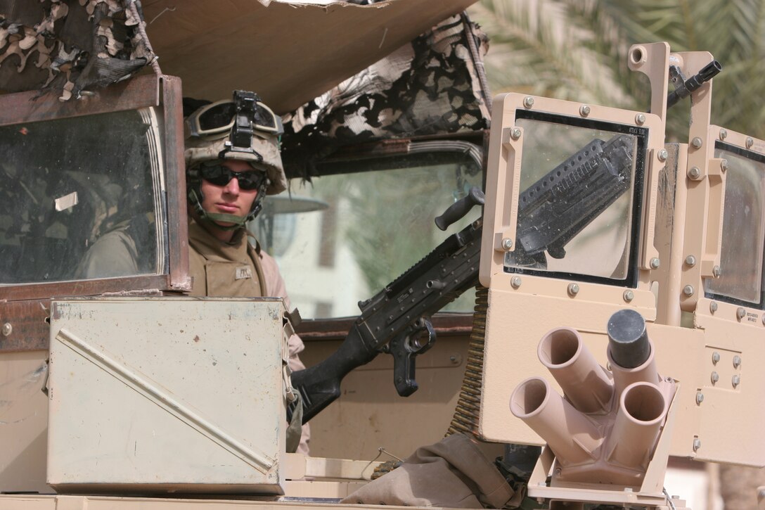 AL TAQADDUM, Iraq (July 25, 2007) ? Lance Cpl. David L. Fry watches Iraqi children as they run by his humvee in Al Madinah as Siyahiyah July 25.  Marines with 1st Battalion, 11th Marine Regiment frequently patrol the nearby area referred to as ?Tourist Town? in defense of Camp Taqaddum. Fry is an intelligence data specialist and Mountain Grove, Mo., native with the battalion.