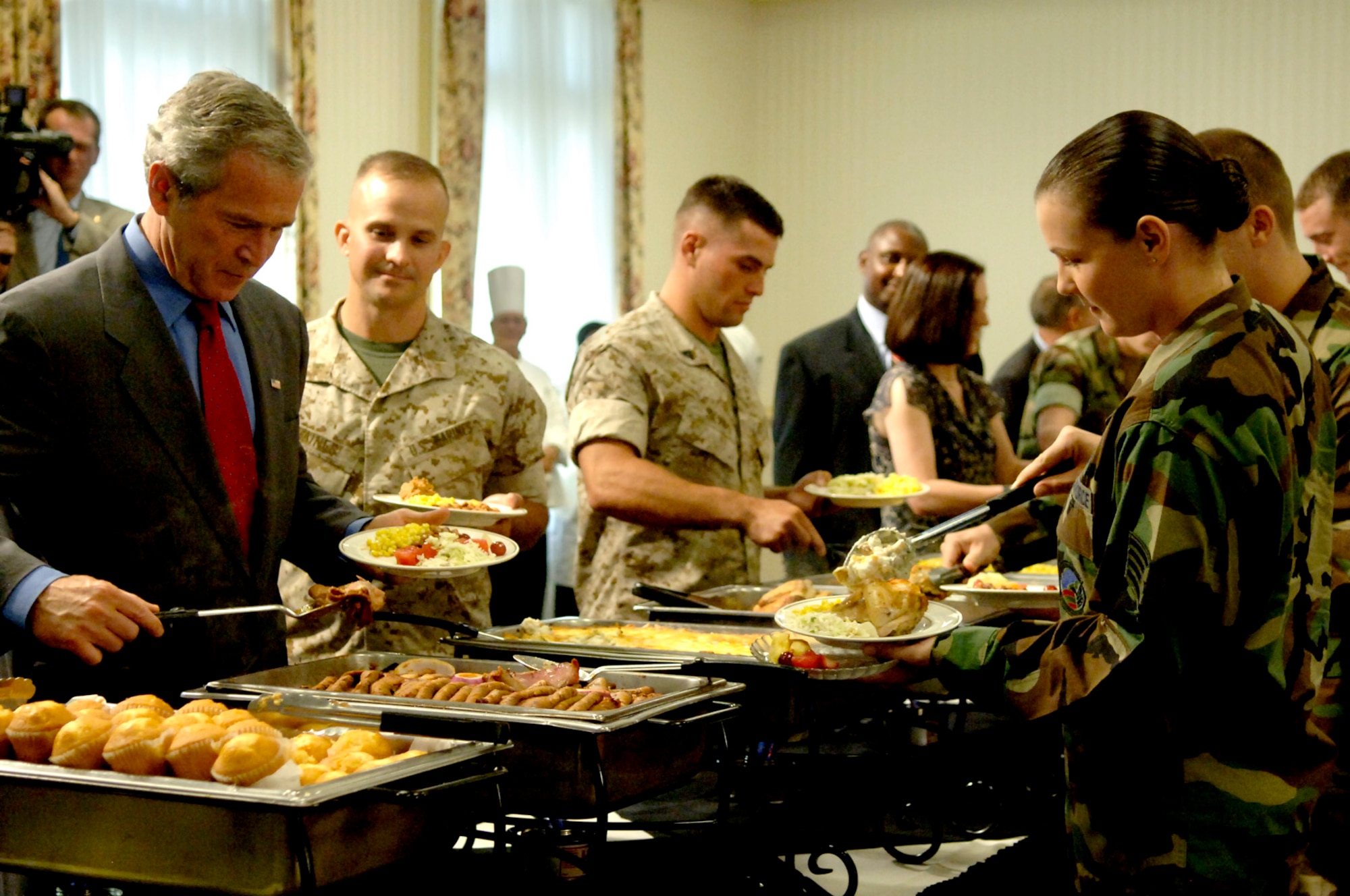 President George Bush prepares a plate of food with military members at the Charleston Club Tuesday. (U.S. Air Force Photo/Airman 1st Class Nicholas Pilch)
