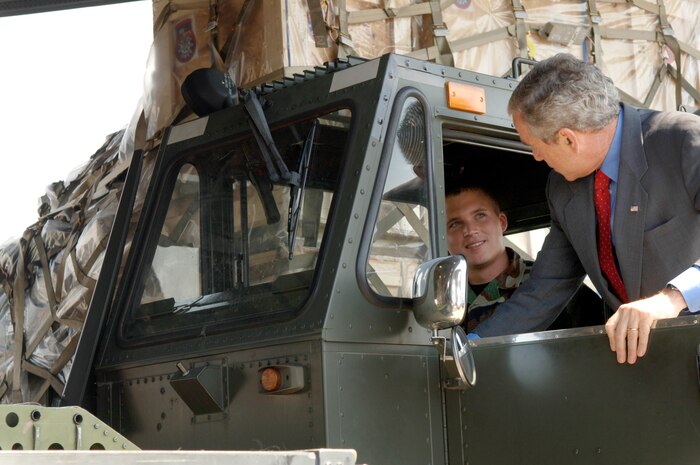 President George Bush talks with Airman 1st Class Joshua Starks, 437th Aerial Port Squadron cargo processor, about loading 
C-17s on the Charleston AFB flightline. (U.S. Air Force Photo/Airman 1st Class Nicholas Pilch)