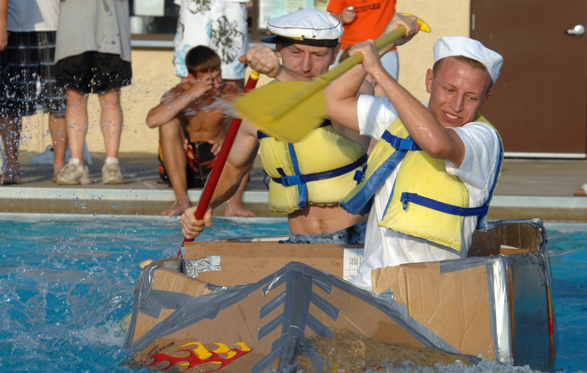 WHITEMAN AIR FORCE BASE, Mo. -- Senior Airman Robert Heidenreich (front) and Staff Sgt. Joshua Hollingshead, both from the 509th Maintenance Squadron, race across the base pool in the S.S. Minnom to a 1st place finish with a time of 14 seconds during the 509th Services Squadron’s Build-a-Boat contest July 20. More than 10 teams had 40 minutes to construct race-worthy boats of cardboard and duct tape. (U.S. Air Force photo/Airman 1st Class Stephen Linch)

