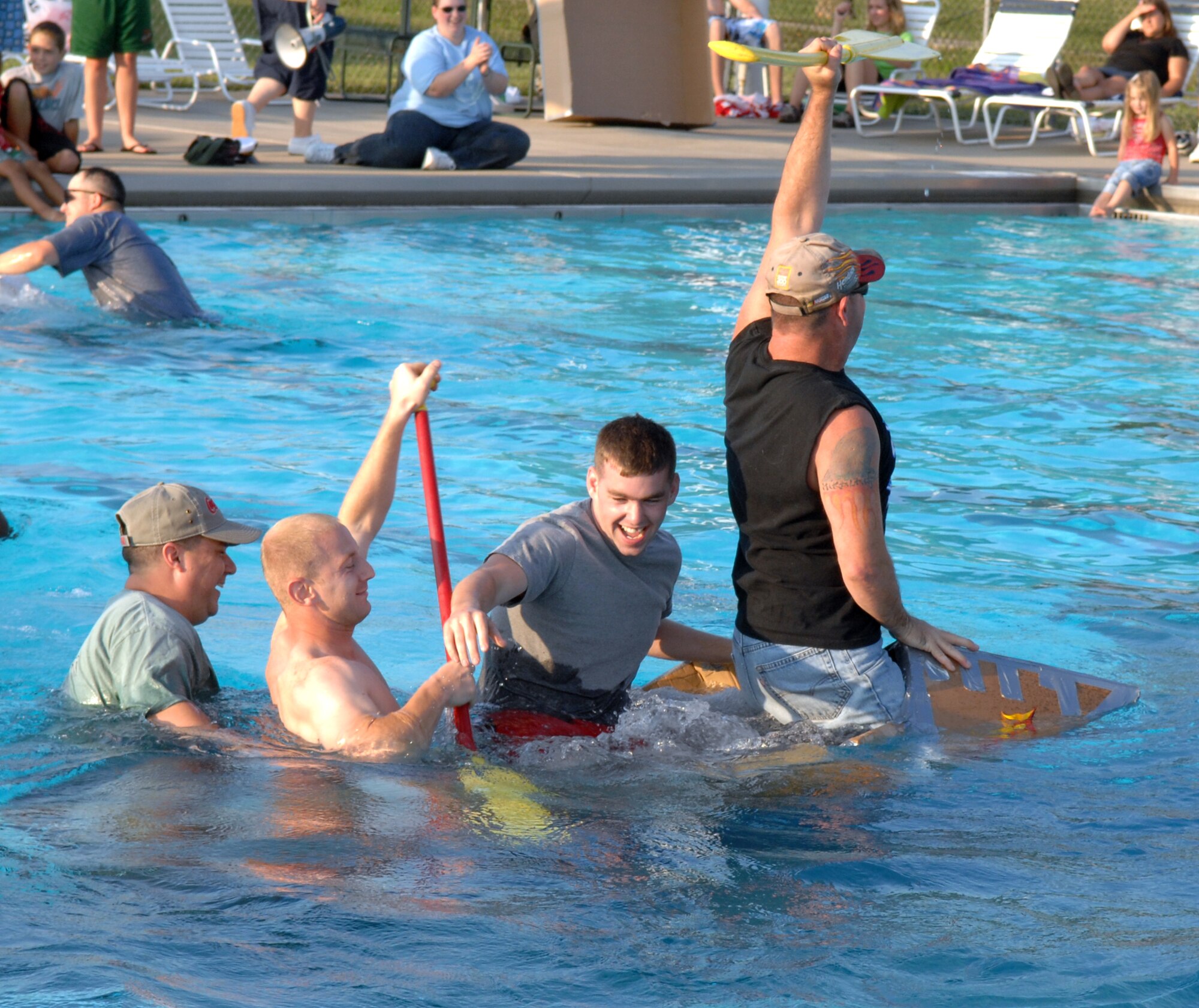 WHITEMAN AIR FORCE BASE, Mo. -- The crew of the S.S. Minnom go down with their cardboard ship during the “best sinking” portion of the Build-a-Boat contest at the base pool July 20. The base pool is open Tuesday through Friday from 1:15 to 6:00 p.m. and Saturday and Sunday noon to 6 p.m. (U.S. Air Force photo/Airman 1st Class Stephen Linch)

