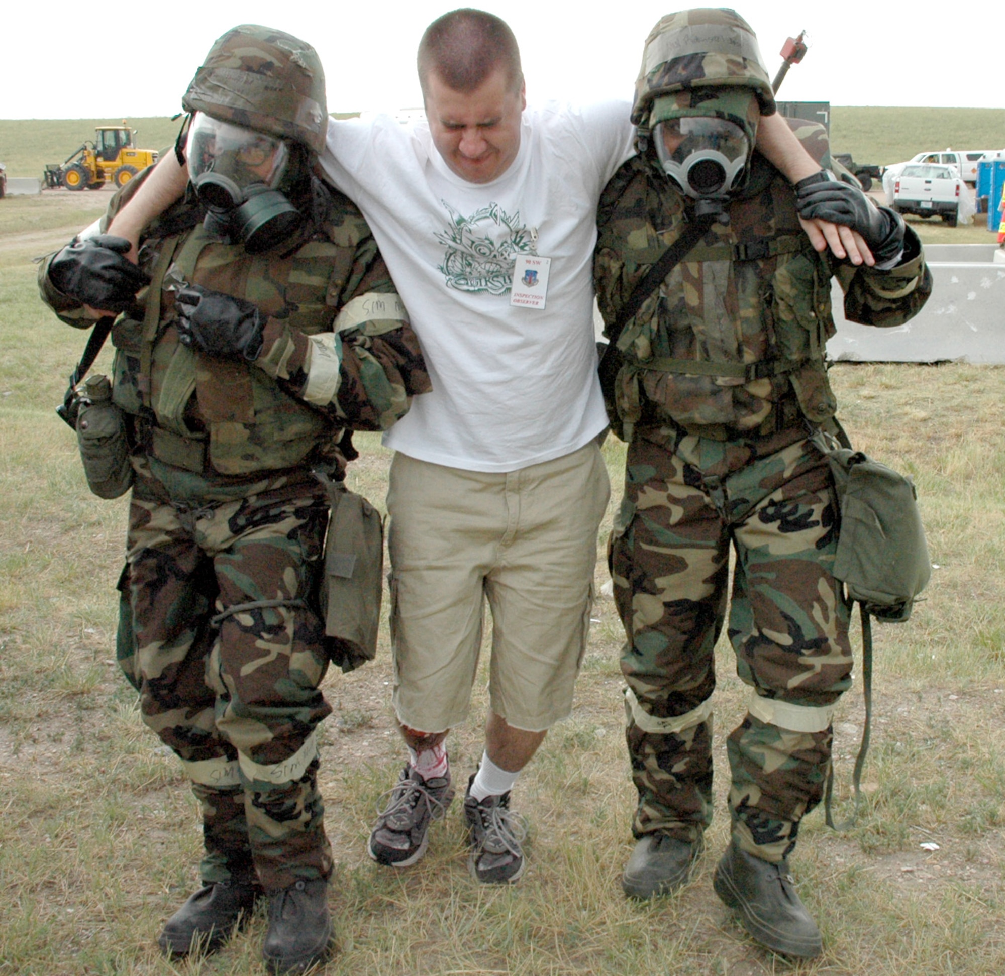 Staff Sgt. Ernest Sheffield, 90th Civil Engineering Squadron, and Airman Joseph Robinson, 90th CES, help Airman 1st Class James Jennings, 90th Missile Maintenance Squadron, to a medical tent.