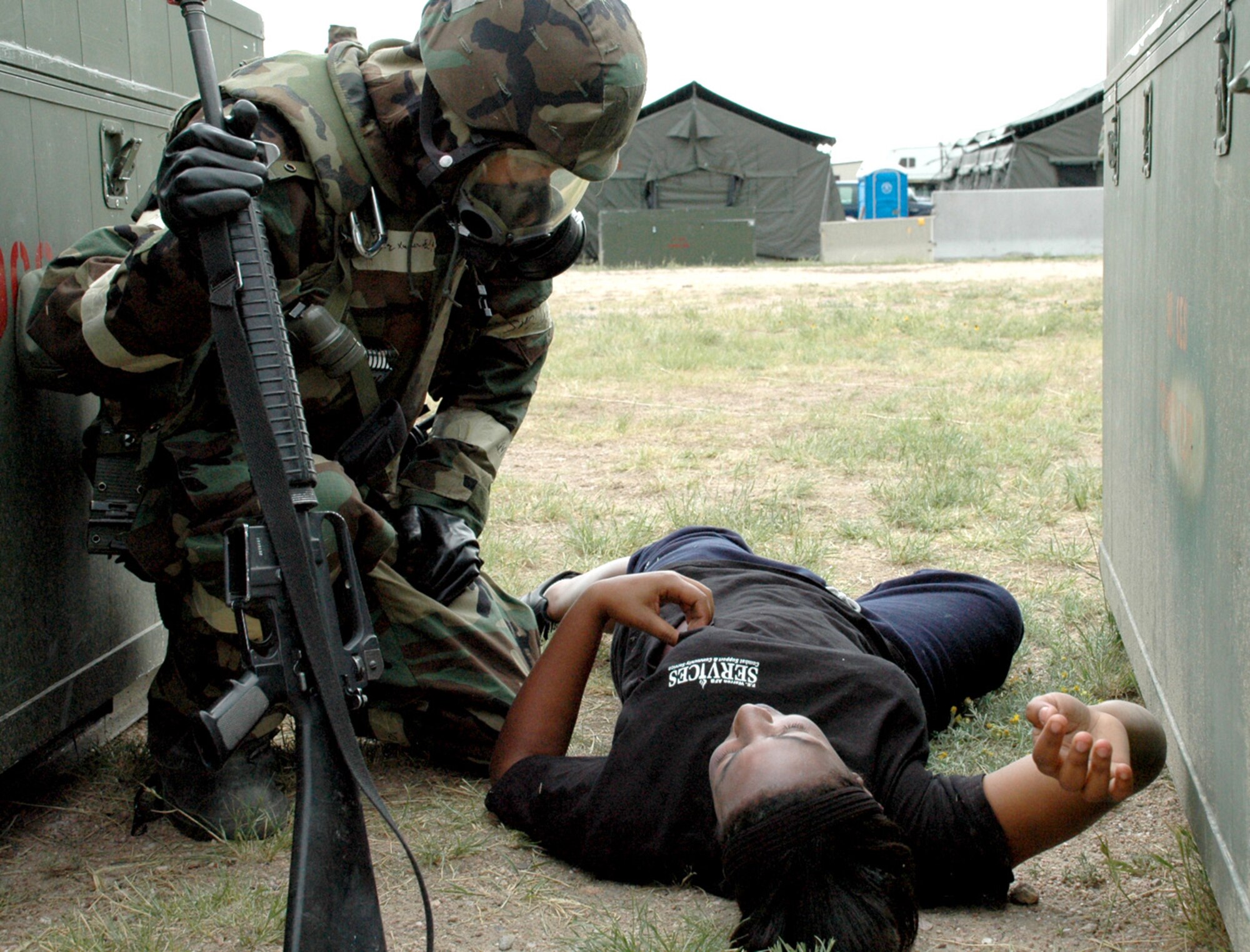 Airman 1st Class Jazmine Clark, 90th Medical Operations Squadron, pretends to suffer from breathing problems while Senior Airman Edy CruzXuarez, 90th Civil Engineering Squadron, discovers her and assists after a simulated mortar attack.