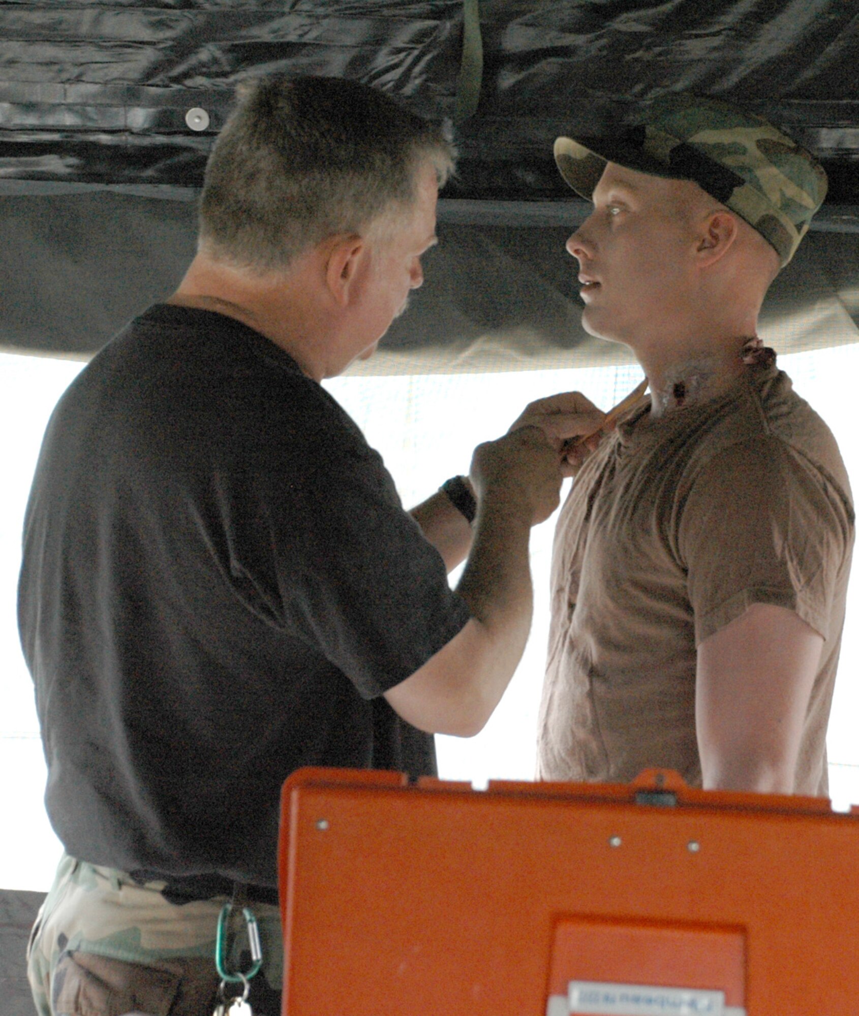 Master Sgt. Lawrence Mason, 90th Medical Operations Squadron, applies injury effects to Airman 1st Class Lee Thorbjornsen, 90th Missile Maintenance Squadron, before a simulated attack.