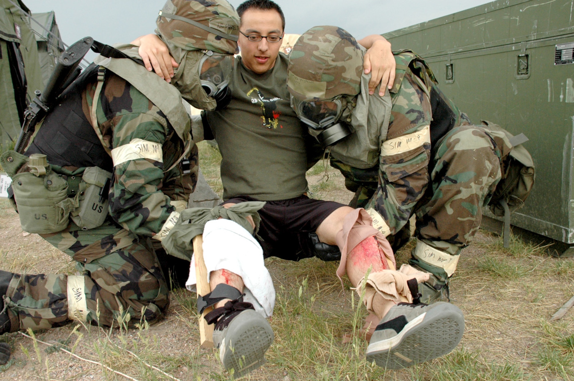 Two Airmen carry Airman 1st Class John Diaz, 90th Medical Support Squadron, to a medical tent. His simulated injuries were two broken legs.