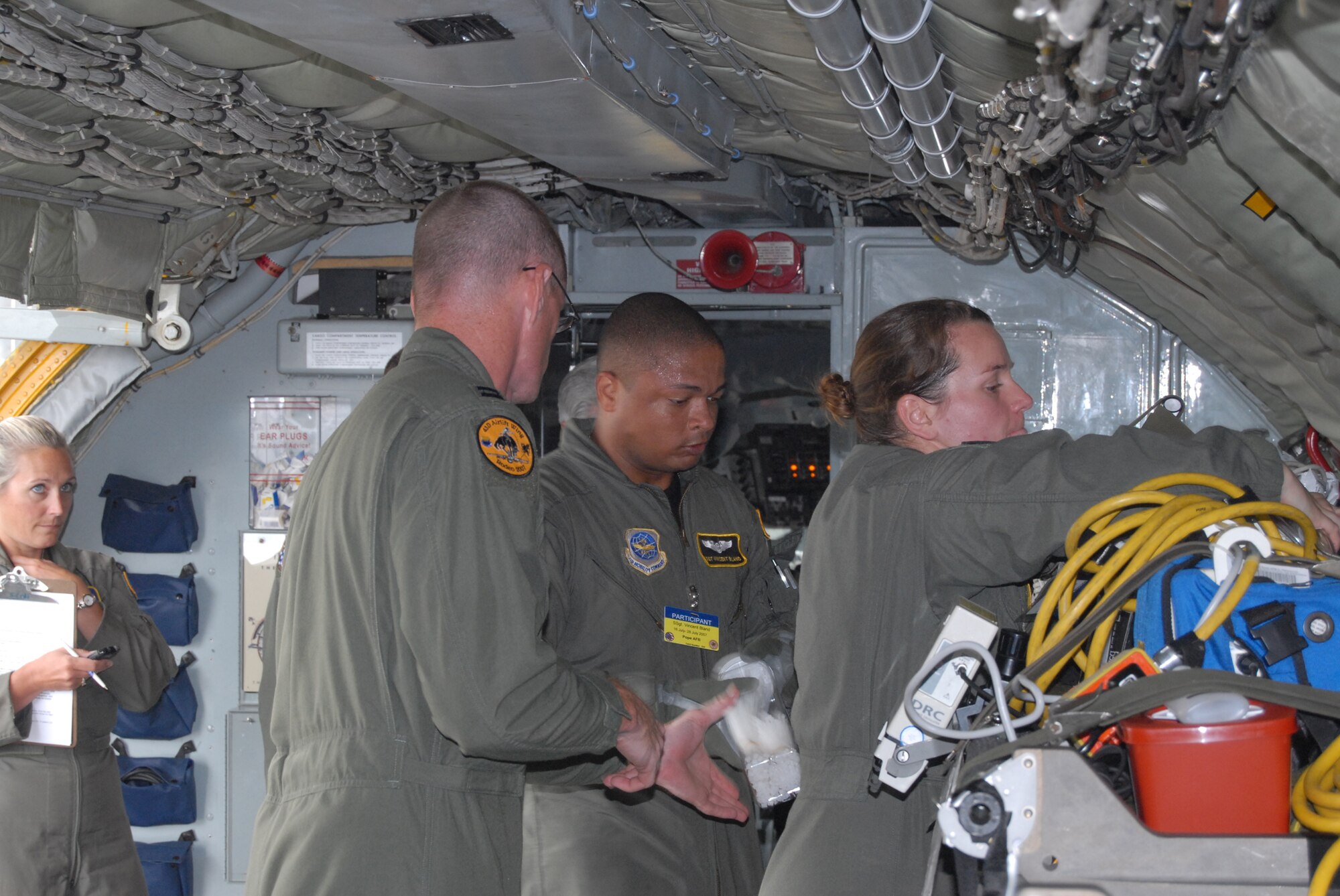 Lt. Col. Tami Rougeau, aeromedical evacuation evaluator, observes Capt. Nathan Ferguson, Staff Sgt. Vincent Bland and Capt. Amy Crow during an aeromedical configuration event on a KC-135 Monday at McChord Air Force Base, Wash. The Pope aeromedical evacuation team also competed in a aeromedical contingency flight and a challenge course. (U.S. Air Force photo/Staff Sgt. Jon Ladue)