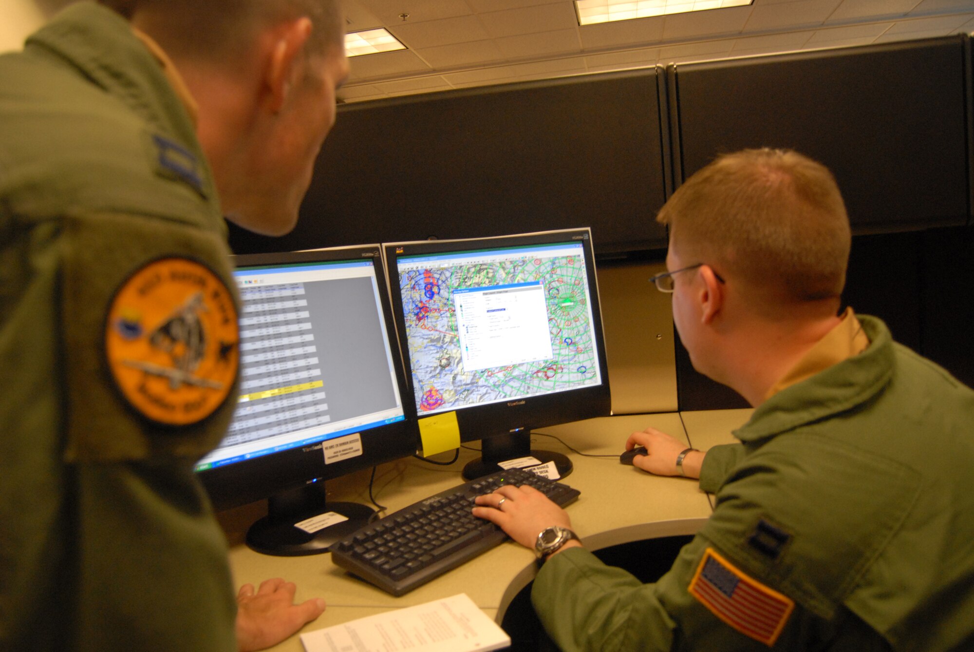 Capt. Nathan Mansfield, 2nd Airlift Squadron C-130 pilot, and Capt. Gregory Leonard, 2nd AS flight navigator, both members of the 2007 Pope Rodeo aircrew team, look over maps to determine a flight path as part of their mission planning Sunday at McChord Air Force Base. The aircrew competes against other C-130 teams in airdrops, assault landings, backing and combat offloads. (U.S. Air Force photo/Staff Sgt. Jon Ladue)
