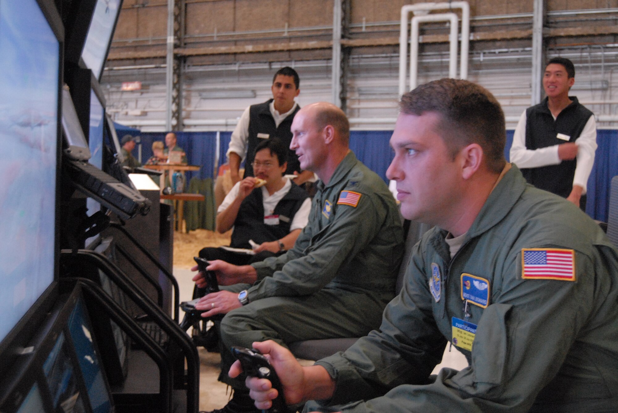 Col. Timothy Zadalis, 43 Airlift Wing Commander and Rodeo spectator, and Master Sgt. Ian Leonard, 2nd Airlift Squadron flight engineer, race one another to land a C-17  on a flight simulator at a vendor booth in Hangar 1, McChord Air Force Base, Wash. Sunday. The 2007 Air Mobility Command Rodeo included different vendors, demonstrations, entertainment and food throughout the week in addition to the many events.. (U.S. Air Force photo/Staff Sgt. Jon Ladue)