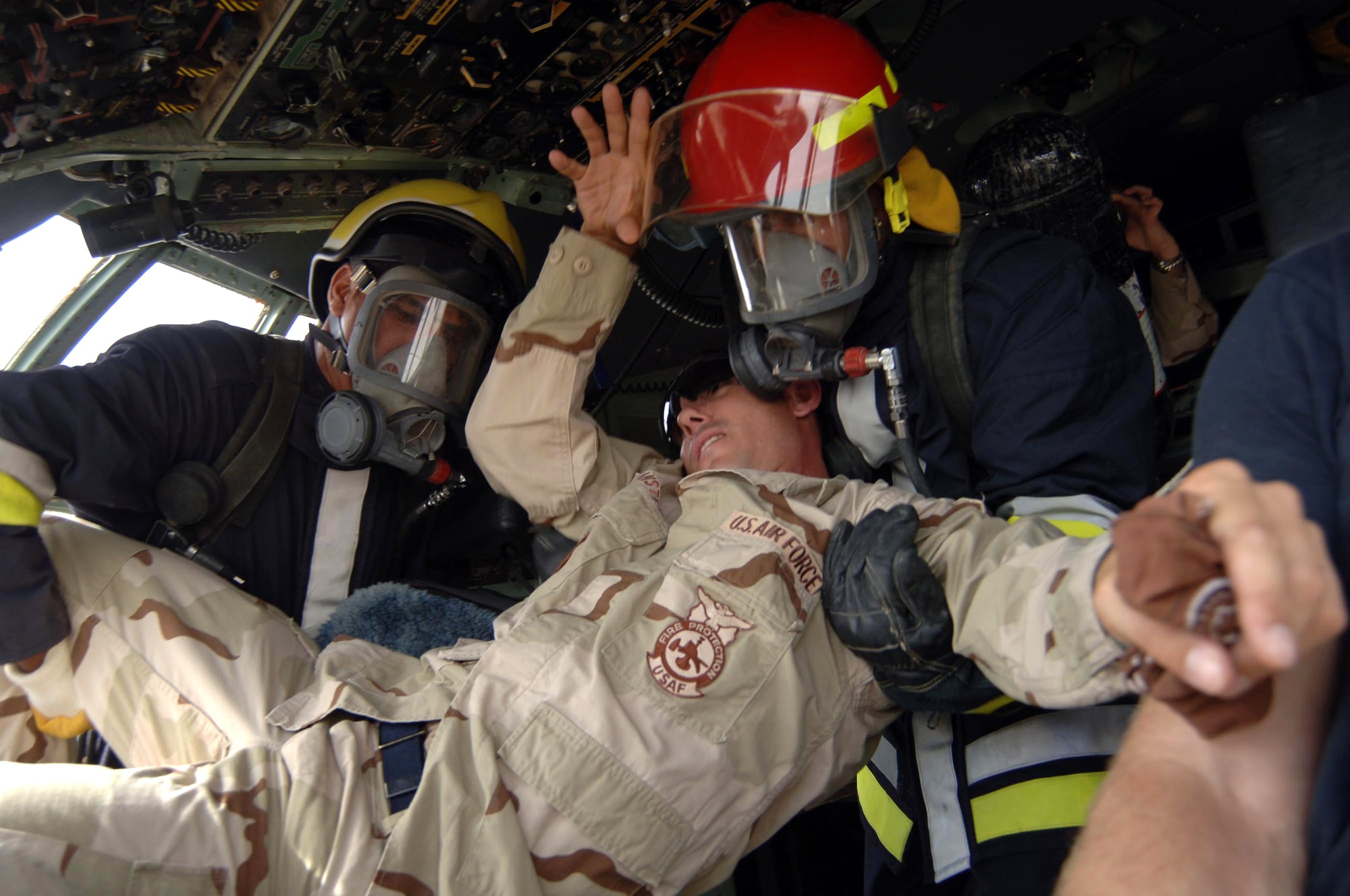 Firefighters from the Iraqi air force remove Staff Sgt. Vance Vansteel from an Iraqi C-130 July 9 at New Al-Muthana Air Base, Iraq. The event was an exercise where Iraqis trained to shut down aircraft engines and remove an unconscious pilot. U.S. Airmen frequently train with Iraqi firefighters in effort to make them more autonomous. Sergeant Vansteel is a 447th Expeditionary Civil Engineer Squadron firefighter. (U.S. Air Force photo/Tech. Sgt. Russell Wicke) 
