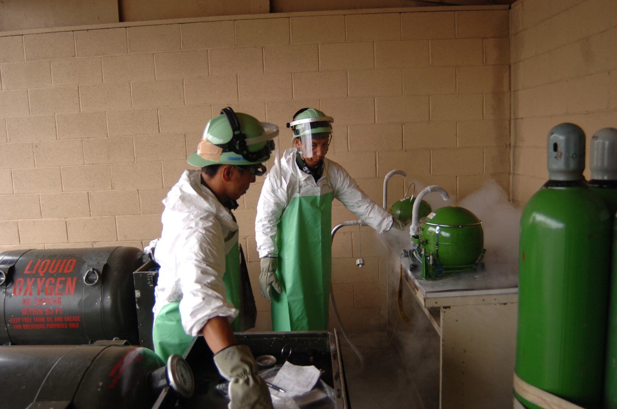 EIELSON AIR FORCE BASE, Alaska -- Master Sgt. Akira Iimura (right) and Tech. Sgt. Shintaro Anami, Airplane General technicians, refill LOX bottles with liquid oxygen. Sergeant's Iimura and Anami, from Japan's Air Self Defense Force, are participating with Red Flag  Alaska 07-3, a multinational air combat training exercise. (U.S. Air Force photo by MSgt Brandt Smith)