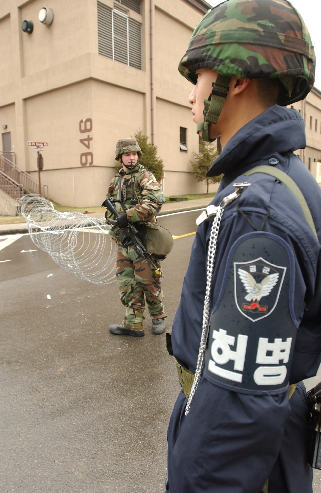 Republic of Korea Airman Kim Young Geung and U.S. Air Force Airman Samuel Lawson guard post 961 during the Reception, Staging, Onward movement, and Integration/Foal Eagle 2007 exercise at Osan Air Base, South Korea. The exercise is an annual joint/combined command post exercise and field training exercise. Airman Lawson is assigned tot he 51st Security Forces Squadron.  (U.S. Air Force photo/Francisco V. Govea II)
