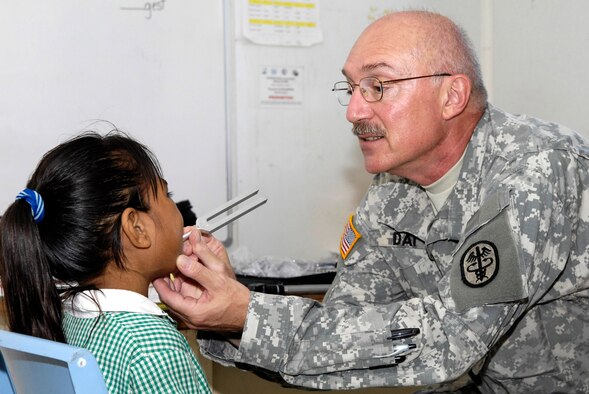 Col. (Dr.) Joe Dai performs a basic hearing test on a Nauruan first grader July 21 on the island of Nauru. Colonel Dai is part of a 12-person, joint-force U.S. Pacific Command team deployed to the south Pacific Island of Nauru to provide assitance and training to the island's medical professionals. Colonel Dai is a pediatrician based out of Tripler Army Medical Center in Hawaii. (U.S. Air Force photo/Tech. Sgt. Chris Vadnais)