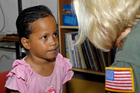 Maj. C.J. Newhouse talks with a first grader while conducting a basic hearing test July 21 on the island of Nauru. Major Newhouse is part of a 12-person, joint-force U.S. Pacific Command team deployed to Nauru to provide medical training and assistance to the island's medical professionals. Major Newhouse is a Reserve flight nurse with the 446th Aeromedical Evacuation Squadron from McChord Air Force Base, Wash. (U.S. Air Force photo/Tech. Sgt. Chris Vadnais)