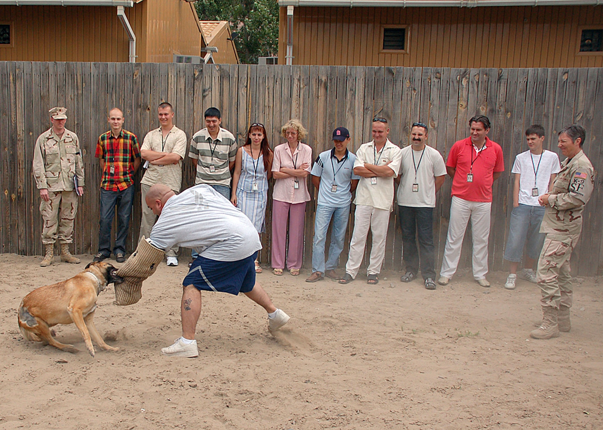 Maj. Michael Smith and controllers from Kyrgyz Air Navigation watch as Rico demonstrates how he stops a potential suspect from escaping during a July 16 visit of Manas Air Base, Kyrgyzstan. Major Smith is the 376th Expeditionary Operations Support Squadron commander, and Rico is a 376th Expeditionary Security Forces Squadron military working dog. Staff Sgt. Jorge Davila, a 376th ESFS dog handler, was the decoy during the demonstration. (U.S. Air Force photo/Staff Sgt. Les Waters) 
