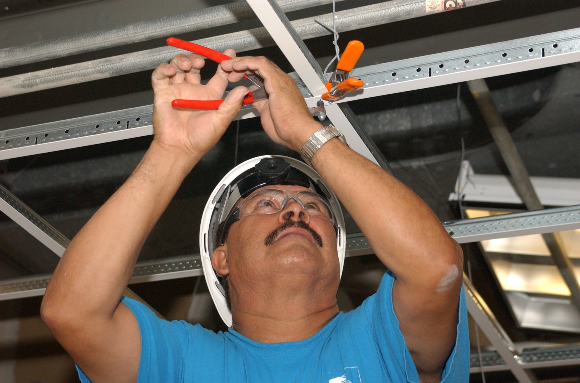 Juan Segura, LTRC Inc. laborer from Richardson, Texas, installs a ceiling grid in Sablich Center.  (U.S. Air Force photo by Kemberly Groue)