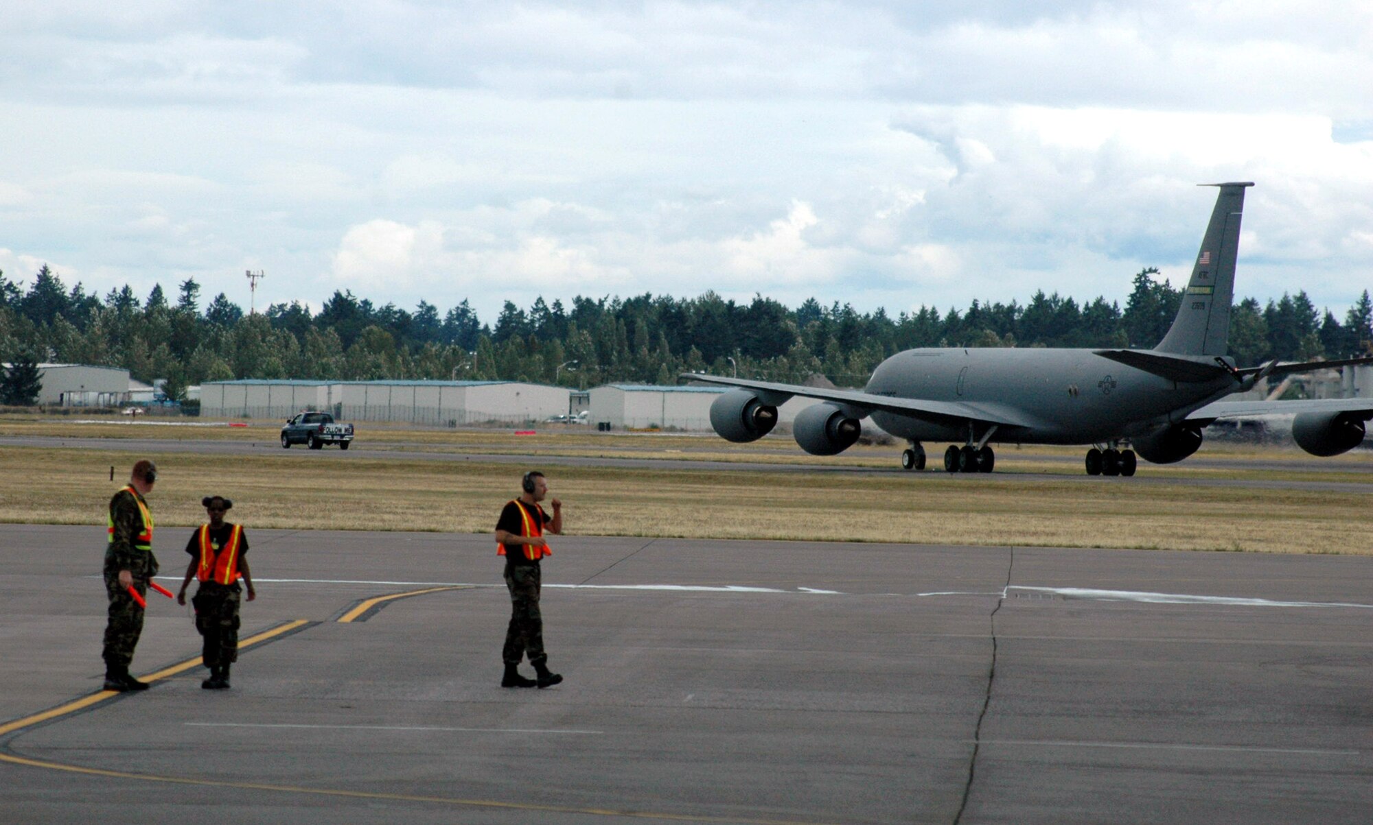 Maintenance Airmen work on the flightline at McChord Air Force Base, Wash., while a KC-135 Stratotanker from Grand Forks AFB, N.D., taxies to a parking area July 21 during operations for Rodeo 2007.  The airlift competition, sponsored by Air Mobility Command, focuses on improving worldwide mobility forces' professional core abilities. More than 40 teams and 2,500 people from the Air Force, and Air Force Reserve, as well as allied nations, are expected to participate. (U.S. Air Force photo/Tech. Sgt. Scott T. Sturkol)