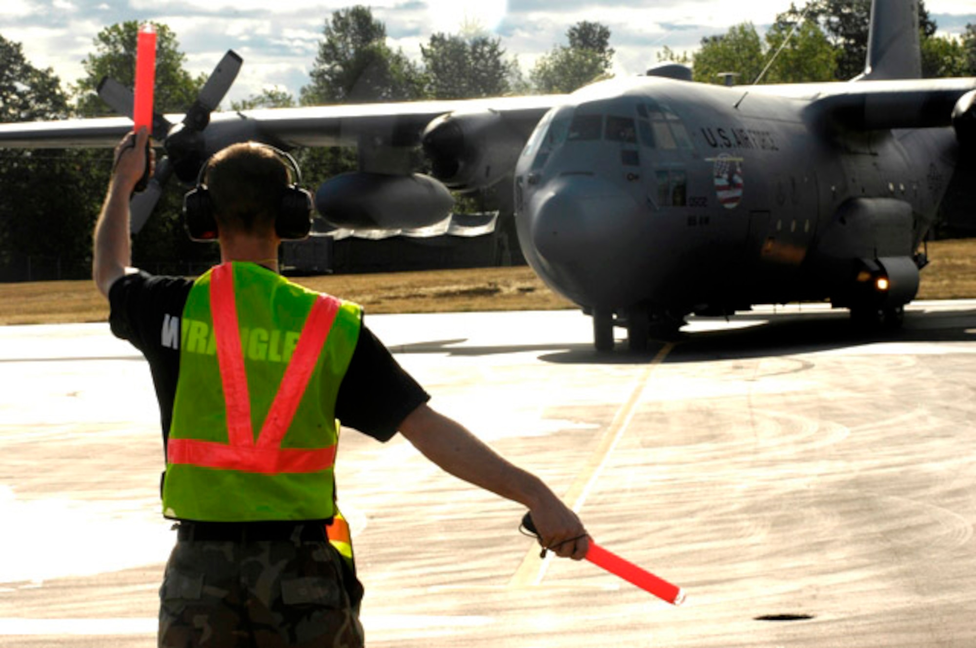 Senior Airman Christian Recene marshals a C-130 Hercules from Ramstein Air Base, Germany, during its July 21 arrival to McChord Air Force Base, Wash. Rodeo 2007, hosted by Air Mobility Command, is an airlift competition of U.S. and international air mobility forces. (U.S. Air Force photo/Airman Jonathan Olds)