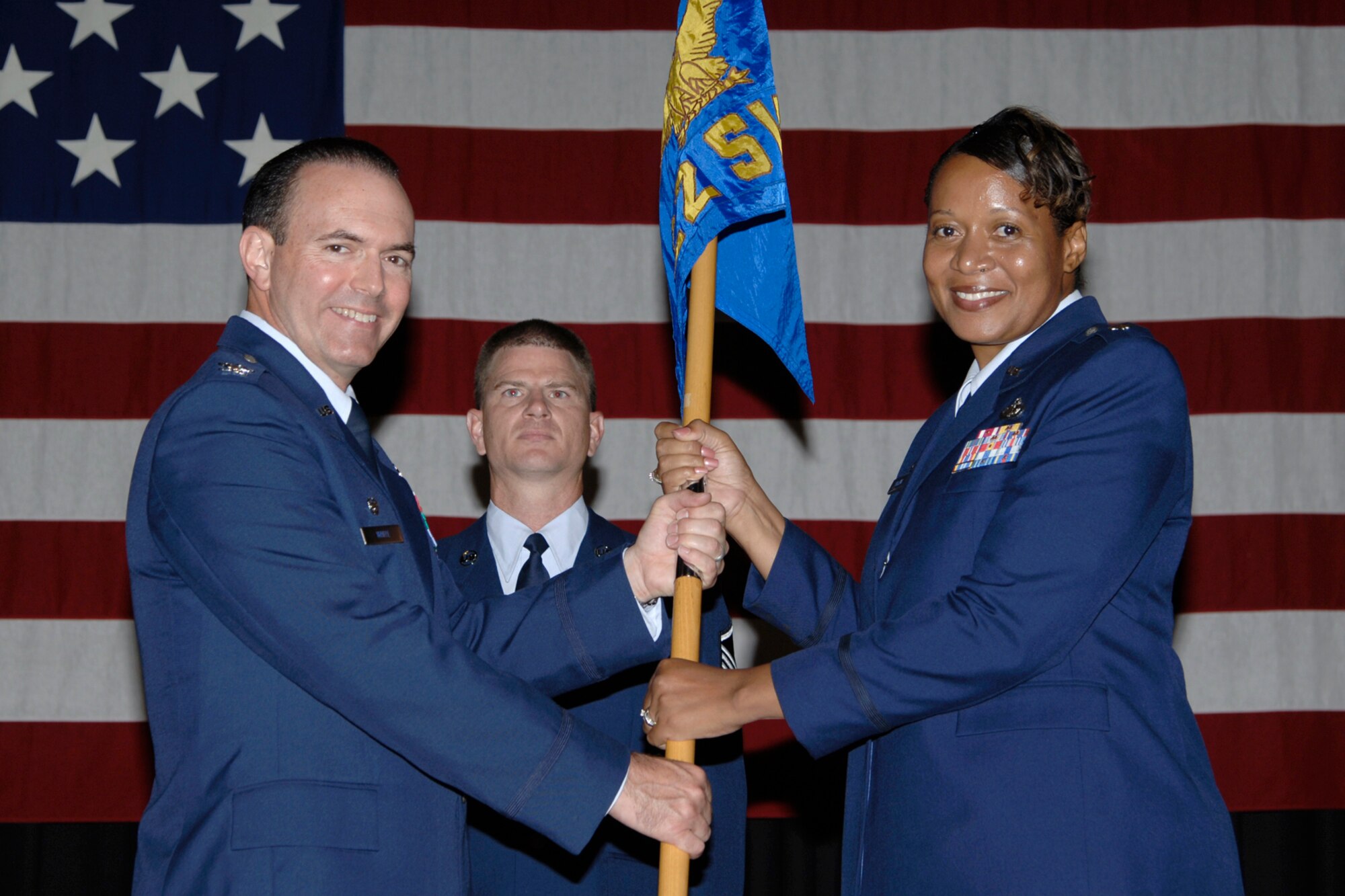 MCCONNELL AIR FORCE BASE, Kan. -- Col. Mark White, 22nd Mission Support Group Commander, hands the guidon to the new 22nd Services Commander, Lt. Col. Sonya Collins, during a change of command ceremony July 17. Lt. Colonel Collins took command from Lt. Col. Donald Meeker. (photo by Senior Airman Jamie Train)