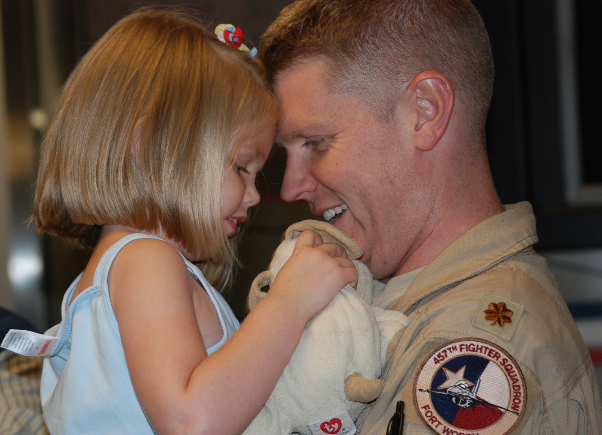 Maj. Chuck Huber's daughter and her furry friend welcome him home at the Dallas/Fort Worth International Airport after a recent deployment. The 457th Fighter Squadron F-16 pilot and nearly 200 Air Force Reserve Airmen from the 301st Fighter Wing out of the Naval Air Station Joint Reserve Base Fort Worth, Texas, were deployed to Balad Air Base, Iraq in support of Operation Iraqi Freedom. (U.S. Air Force Photo/Laura Dermarderosian-Smith)