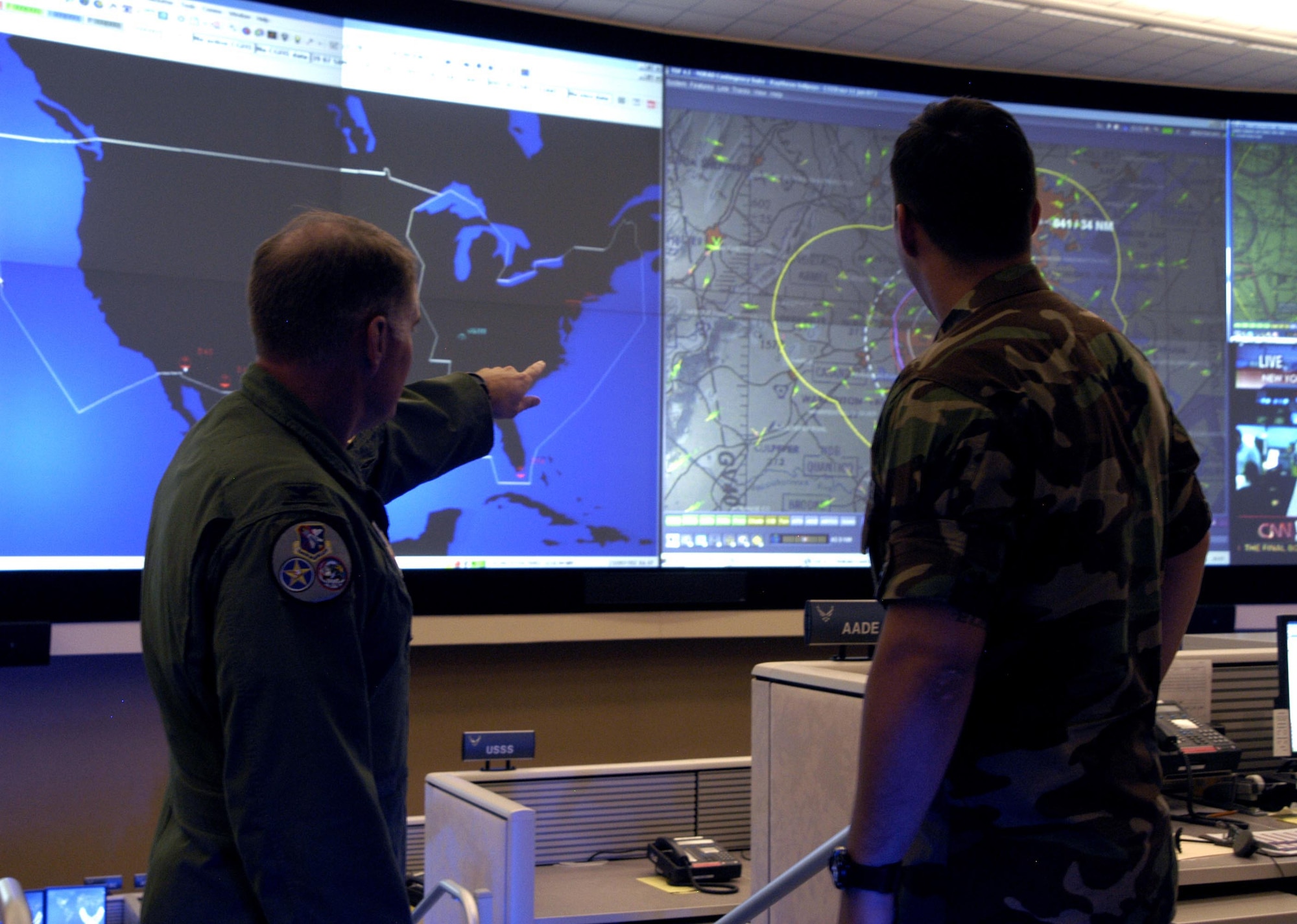 Col. Kriner shows 2nd Lt. Andrew Scott, 601st AOC, air tracks over the National Capital Region. The new AOC is equipped with a $3.5 million data wall to better monitor air traffic across the nation.                                