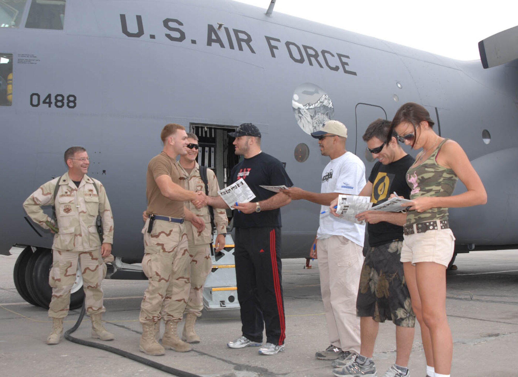 Ultimate Fighting Champions (from left to right) Heath Herring, Jorge Rivera, Kenny Florian and Amber Nicole Miller, the Octagon Girl, greet and sign autographs for the maintenance crews of the C-130 Hercules July 24 at Bagram Airfield, Afghanistan. (U.S. Air Force photo by Senior Master Sergeant Kim Allain)