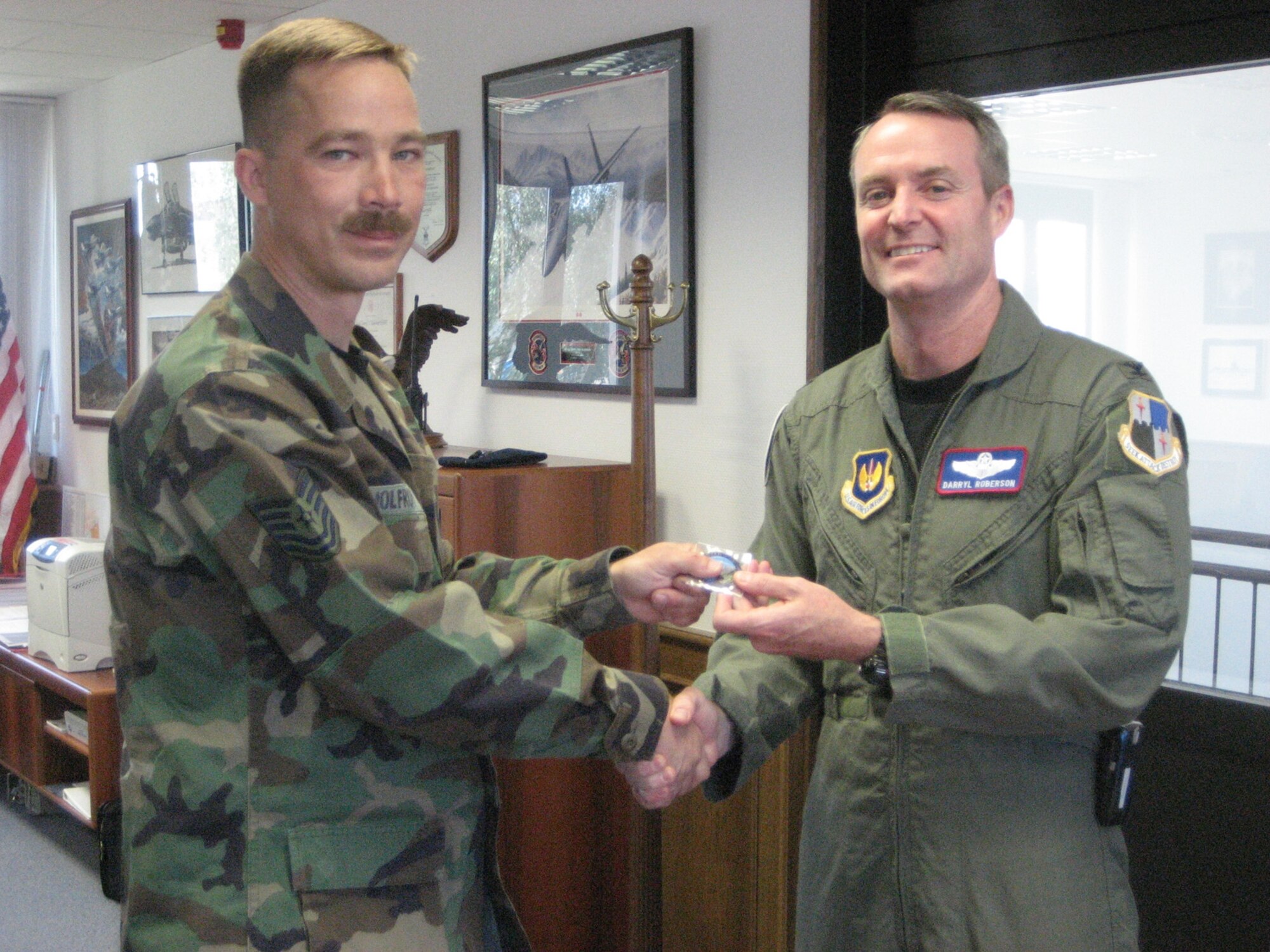 SPANGDAHLEM AIR BASE, Germany – Col. Darryl Roberson, 52nd Fighter Wing commander, presents a Wingman coin to Tech. Sgt. Dan Wolfrum, a structural craftsman from the 52nd Civil Engineer Squadron operations flight, July 16. Sergeant Wolfrum was walking his dog and a friend’s through base housing at about 4:30 a.m. July 12 noticed a fire in a base housing unit. Sergeant Wolfrum’s quick thinking and actions lead to the rescue of a fellow Airman. (U.S. Air Force photo/Staff Sgt. Andrea Knudson)