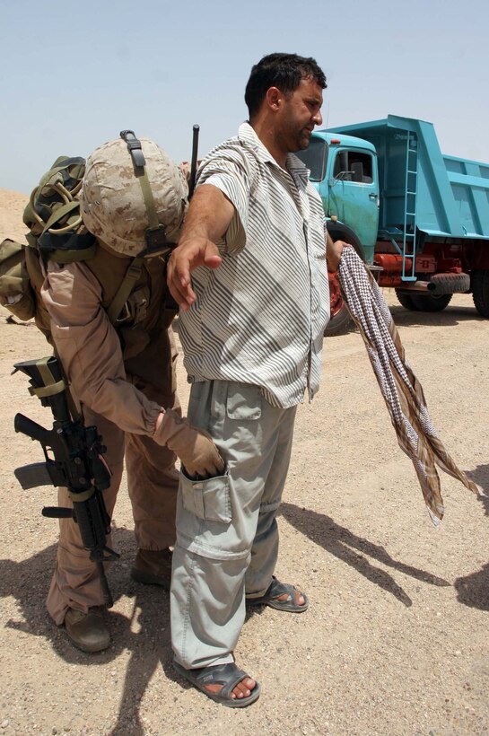 July 26, 2007. AO Topeka, Iraq. Sgt Cody R. Bigham, patrol leader 1st Battalion, 11th Marine Regiment (1/11), searches through the pockets of a Local National, who was stopped on the roadside of Route Lyman during a security patrol conducted by 1/11. 1st Battalion, 11th Marine Regiment is deployed with Multi National Forces-West in support of Operation Iraqi Freedom in the Al Anbar province of Iraq to develop Iraqi Security Forces, facilitate the development of official rule of law through democratic reforms, and continue the development of a market based economy centered on Iraqi reconstruction. (Official USMC photograph by Cpl Michael J O'Brien)