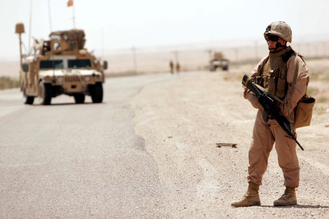 AL TAQADDUM, Iraq (July 26, 2007) - Cpl. Thomas Stephenson, 1st Battalion, 11th Marine Regiment, provides security on a long halt during a security patrol of a nearby route here. 1st Bn., 11th Marines is deployed here with Multi National Forces-West in support of Operation Iraqi Freedom in the Al Anbar province of Iraq to develop Iraqi Security Forces, facilitate the development of official rule of law through democratic reforms, and continue the development of a market based economy centered on Iraqi reconstruction.