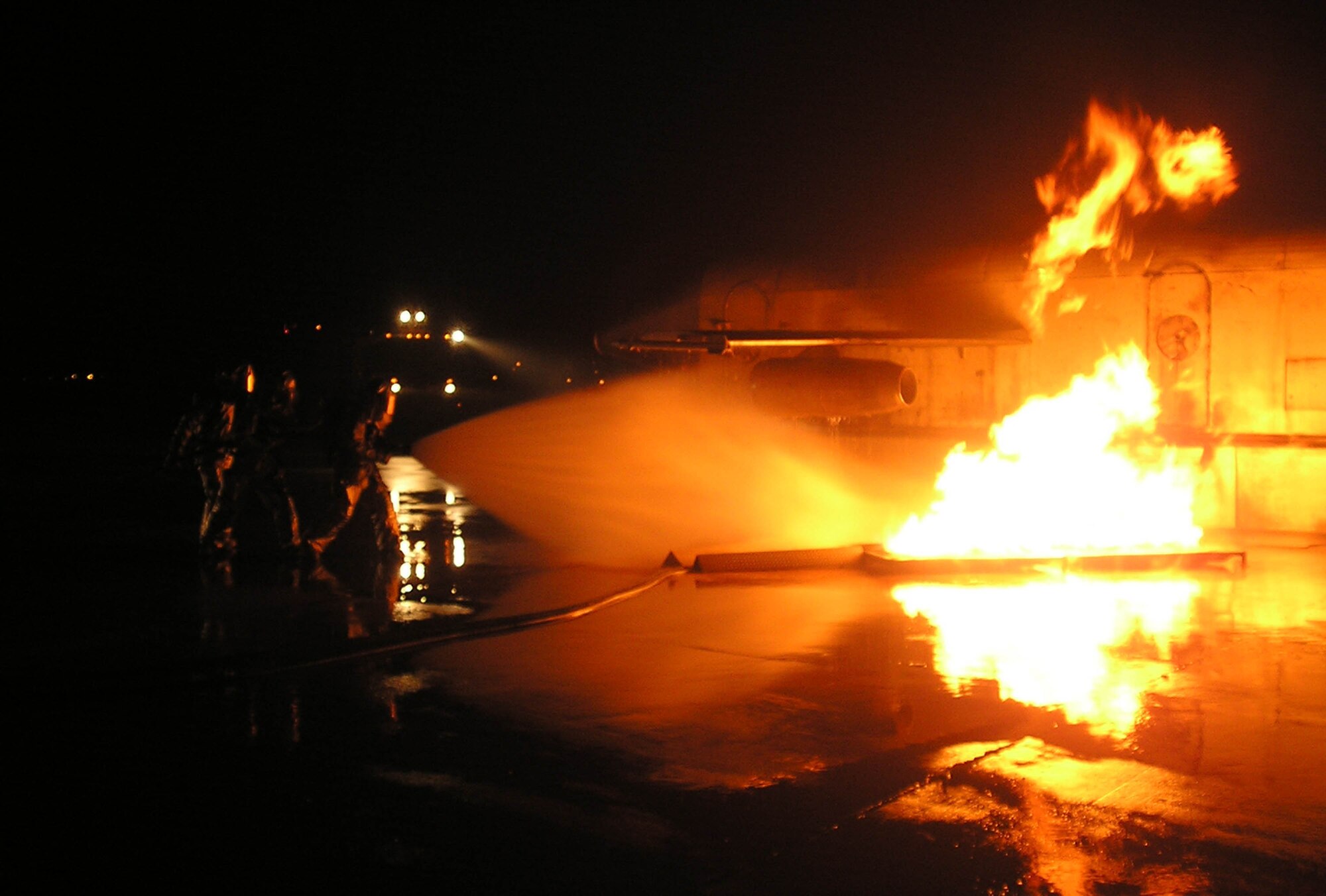 KUNSAN AIR BASE, Republic of Korea -- Firefighters Staff Sgt. David Call and Airmen 1st Class Christopher Osborne and Mark Brandt battle a blaze here during a training scenario July 26. The realistic training, conducted during the quarterly Seventh Air Force Peninsula Combat Employment Readiness Exercise July 23 - 27, helps firefighters here hone their emergency response skills in the event of an aircraft fire. Each firefighter is assigned to the 8th Civil Engineer Squadron fire and emergency services flight. (U.S. Air Force photo/Master Sgt. Victor Davis)