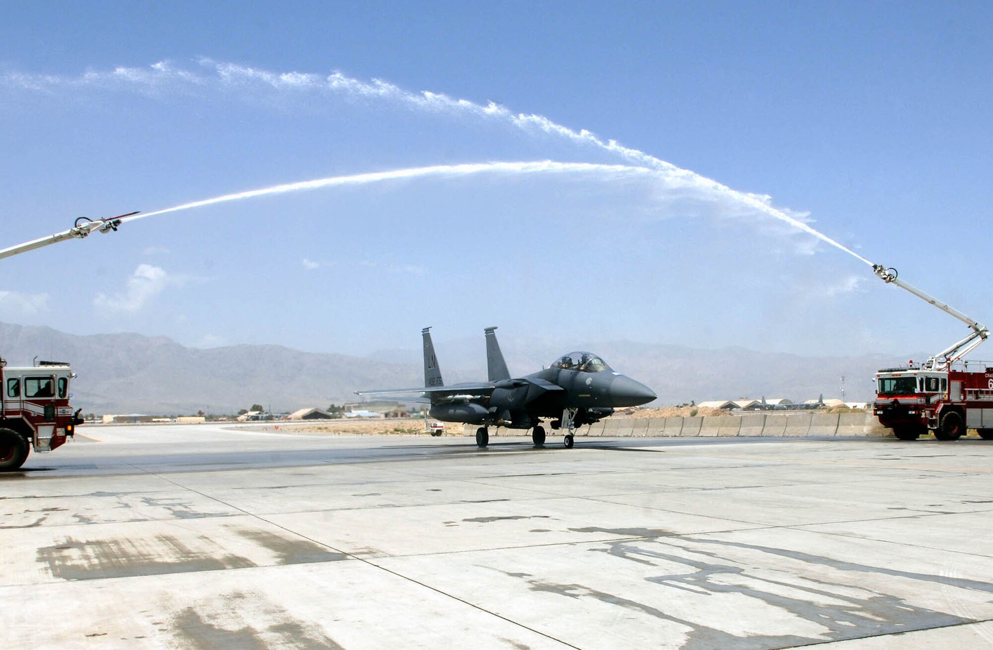 Lt. Col. Dave Iverson, 492nd Expeditionary Fighter Squadron, taxis under an arcing cascade of water celebrating his completion of more than 3,000 flight hours in the F-15E Strike Eagle July 25 at Bagram Airfield, Afghanistan. Col. Iverson is only the 15th pilot to cross this milestone in the F-15E and is deployed from RAF Lakenheath. (U.S. Air Force photo by Staff Sgt. Craig Seals)