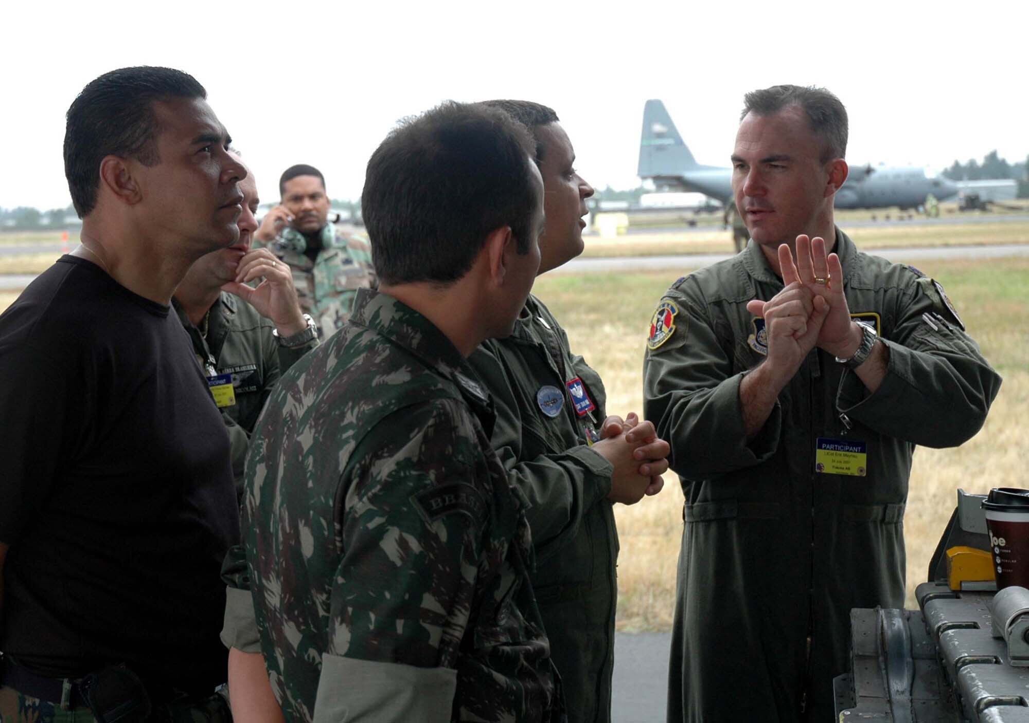 Lt. Col. Eric Mayheu, 374th Operations Group Commander, Yokota Air Base, Japan, explains a maintenance procedure to Rodeo 2007 observers from Brazil at McChord Air Force Base, Wash.  After noticing a hydraulic leak on their C-130E Hercules, maintainers from the 374th Maintenace Squadron scrambled to fix the problem before the heavy air drop portion of the competition.  (U.S. Air Force Photo/Staff Sgt. Nick Przybyciel)