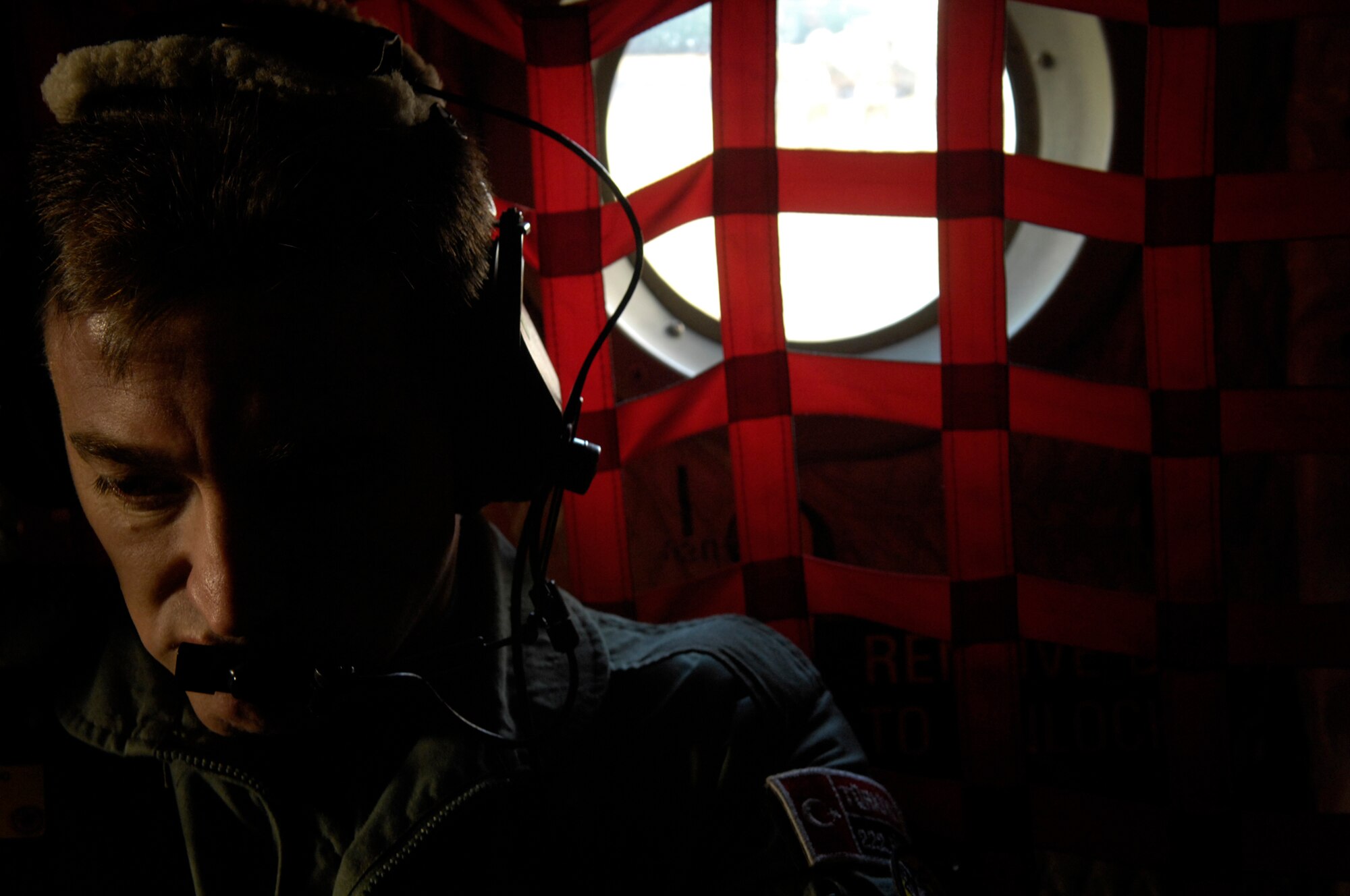 Turkish Air Force Chief Master Sgt. Kayhan Kilik, Air Mobility Rodeo 2007 Umpire, listens to his communication headset at McChord Air Force Base, Wash., July 24 during Rodeo 2007. Air Mobility Command's Rodeo 2007 is a readiness competition of U.S. and international mobility air forces.  It focuses on improving war fighting capabilities and support of the Global War on Terrorism. (U.S. Air Force Photo/Senior Airman Patrick J Dixon) 


