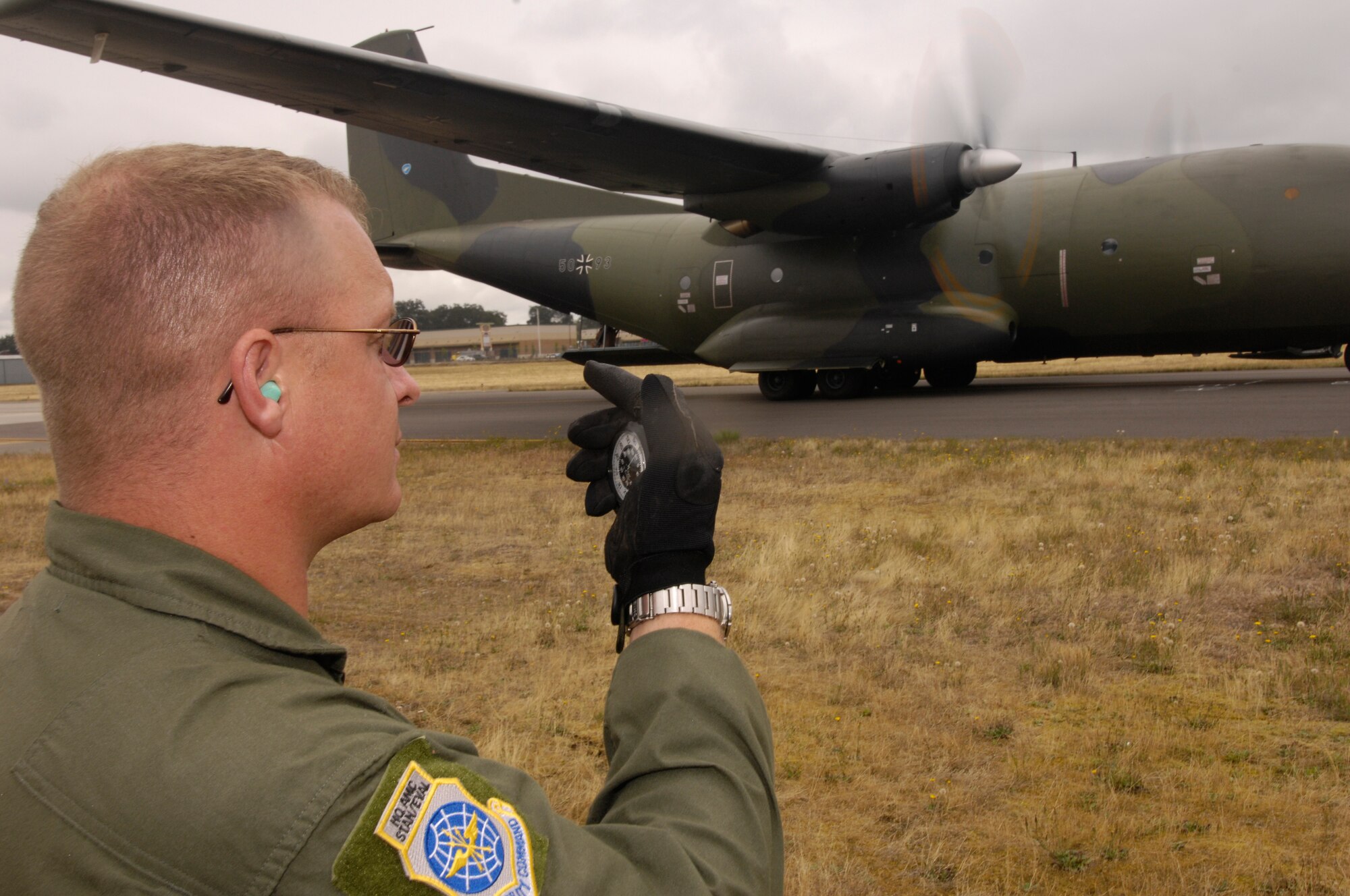 Master Sgt. Russell Lindfors, an umpire for Air Mobility Rodeo 2007 from Scott Air Force Base, Ill., clocks  the amount of time taking for Germany's C-160 Transall to perform a combat off-load event for Rodeo July 23 at McChord AFB, Wash. Rodeo is a readiness competition of U.S. and international mobility air forces.  It focuses on improving warfighting capabilities and support of the Global War on Terrorism.  (U.S. Air Force Photo/Staff Sgt. Samuel Bendet) 