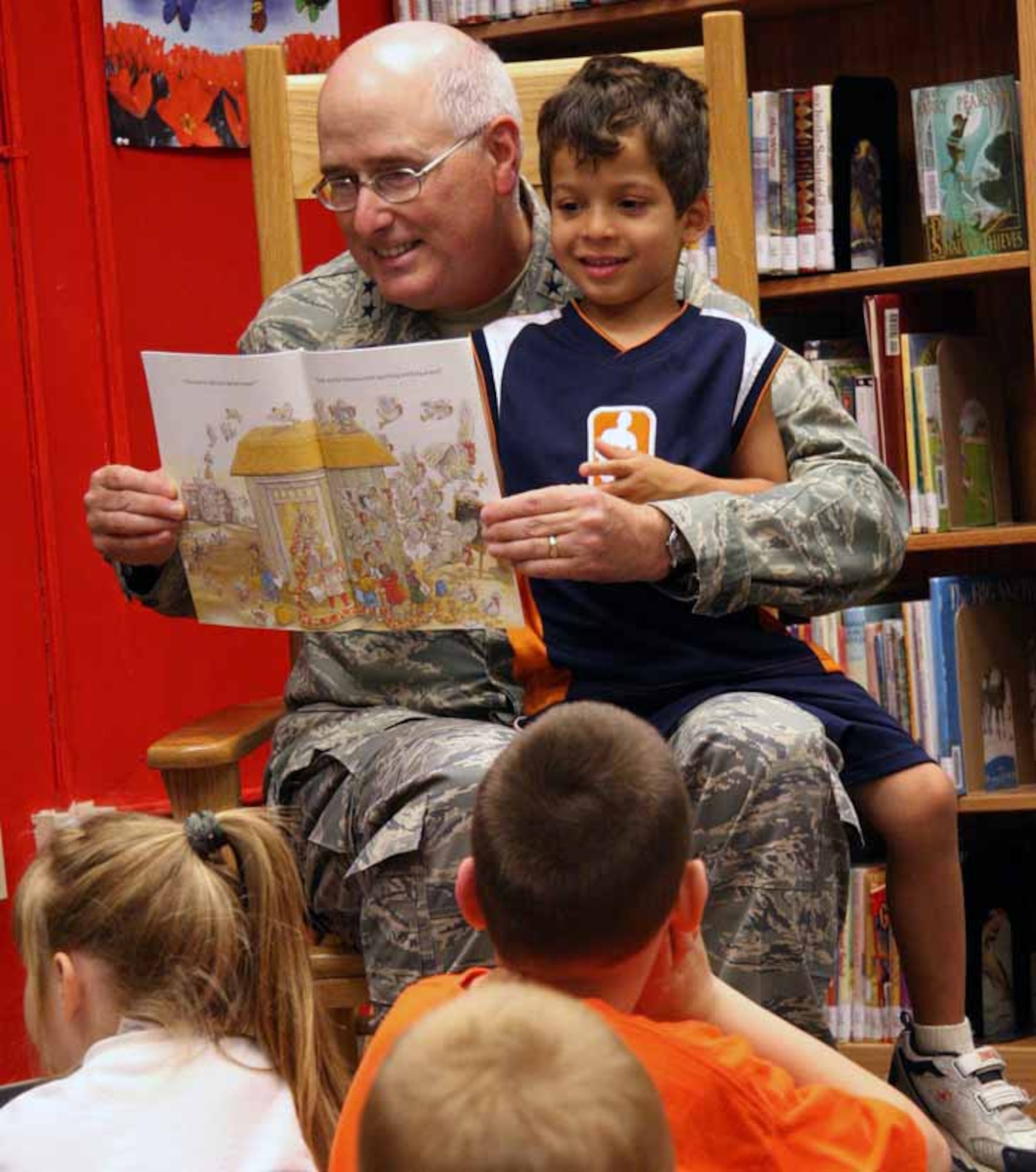 Five-year-old Jovannie Arroyo helps Maj. Gen. Lorren Reno, Oklahoma City Air Logistics Center commander, read to children during the Tinker Library's story time July 19. (Air Force photo by Becky Pillifant)