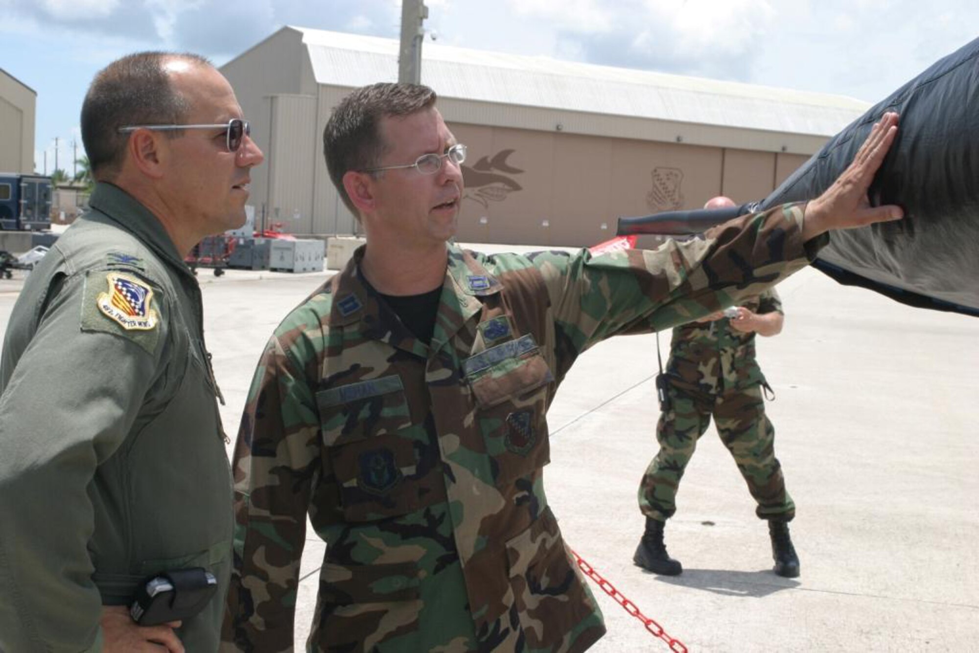 Capt. Rob Mehan, Maintenance Operations Officer, gives 482nd Fighter Wing Commander Col. Randy Falcon a tour of the newly refurbished 482FW Flagship here July 15. 482nd Maintenance Group Airmen presented the commander with a pristine jet after a flawless repainting and meticulous cleaning. Each Air Force wing commander of a flying unit is authorized an aircraft designated as the flagship, or commander’s plane. (U.S. Air Force photo/Tech. Sgt. Paul Dean)