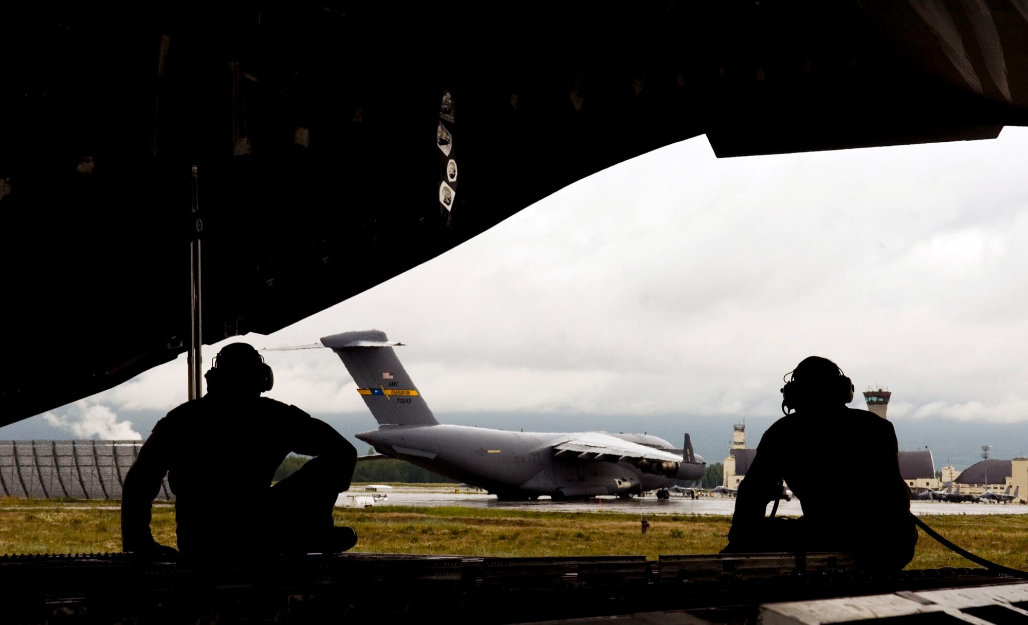Staff Sgt. Justin Mulder (right), and Senior Airman Keith Roscoe sit in the back of a C-17 Globemaster III as the aircraft taxies following a Red Flag-Alaska training sortie July 24 at Elmendorf Air Force Base, Alaska. Sergeant Mulder is assigned to the 517th Airlift Squadron at Elmendorf AFB, and Airman Roscoe is assigned to the 535th AS at Hickam AFB, Hawaii. More than 80 aircraft and 1,500 servicemembers from the six countries are flying together in this multinational exercise that provides realistic combat training in a safe and controlled setting over the Pacific Alaskan Range Complex and Eielson AFB, Alaska. (U.S. Air Force photo/Senior Airman Garrett Hothan) 
