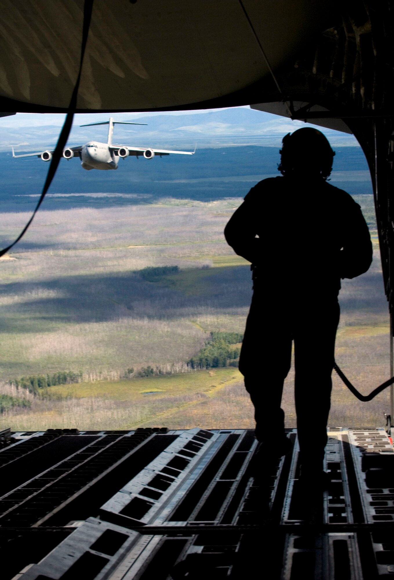 Staff Sgt. Justin Mulder prepares to drop cargo out the bay door of a C-17 Globemaster III during Red Flag-Alaska flight operations July 24 over an Alaskan training range. Sergeant Mulder is a loadmaster assigned to the 517th Airlift Squadron at Elmendorf Air Force Base, Alaska. More than 80 aircraft and 1,500 servicemembers from the six countries are flying together in this multinational exercise that provides realistic combat training in a safe and controlled setting over the Pacific Alaskan Range Complex and Eielson AFB, Alaska. (U.S. Air Force photo/Senior Airman Garrett Hothan) 

