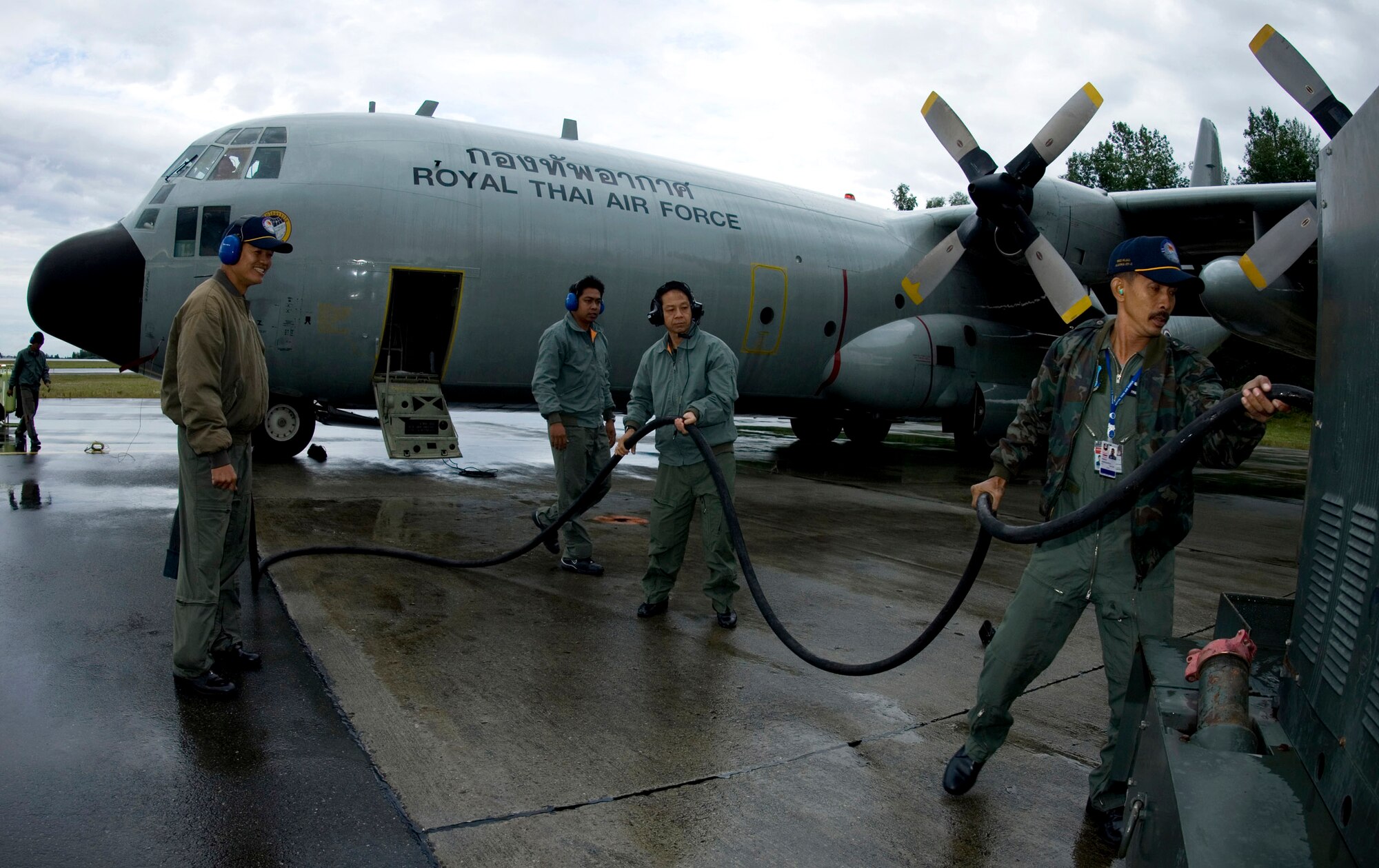 C-130 maintainers with the Royal Thai air force work through their pre-flight maintanence checks on their aircraft on the rain-soaked runway of Elmendorf Air Force Base, Alaska, July 23 during Red Flag-Alaska 2007. More than 80 aircraft and 1,500 servicemembers from the six countries are flying together in this multinational exercise that provides realistic combat training in a safe and controlled setting over the Pacific Alaskan Range Complex and Eielson AFB, Alaska. (U.S. Air Force photo/Senior Airman Garrett Hothan)