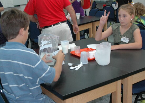 STARBASE La., Summer Academy student Emily Ilgenfritz communicates written directions on how to make ice cream to student Thailer Villarreal without speaking. This supplemental exercise was used to further emphasize the importance of various forms of communication in engineerig and design. (U.S. Air Force photo/Tech. Sgt. Sherri Bohannon)