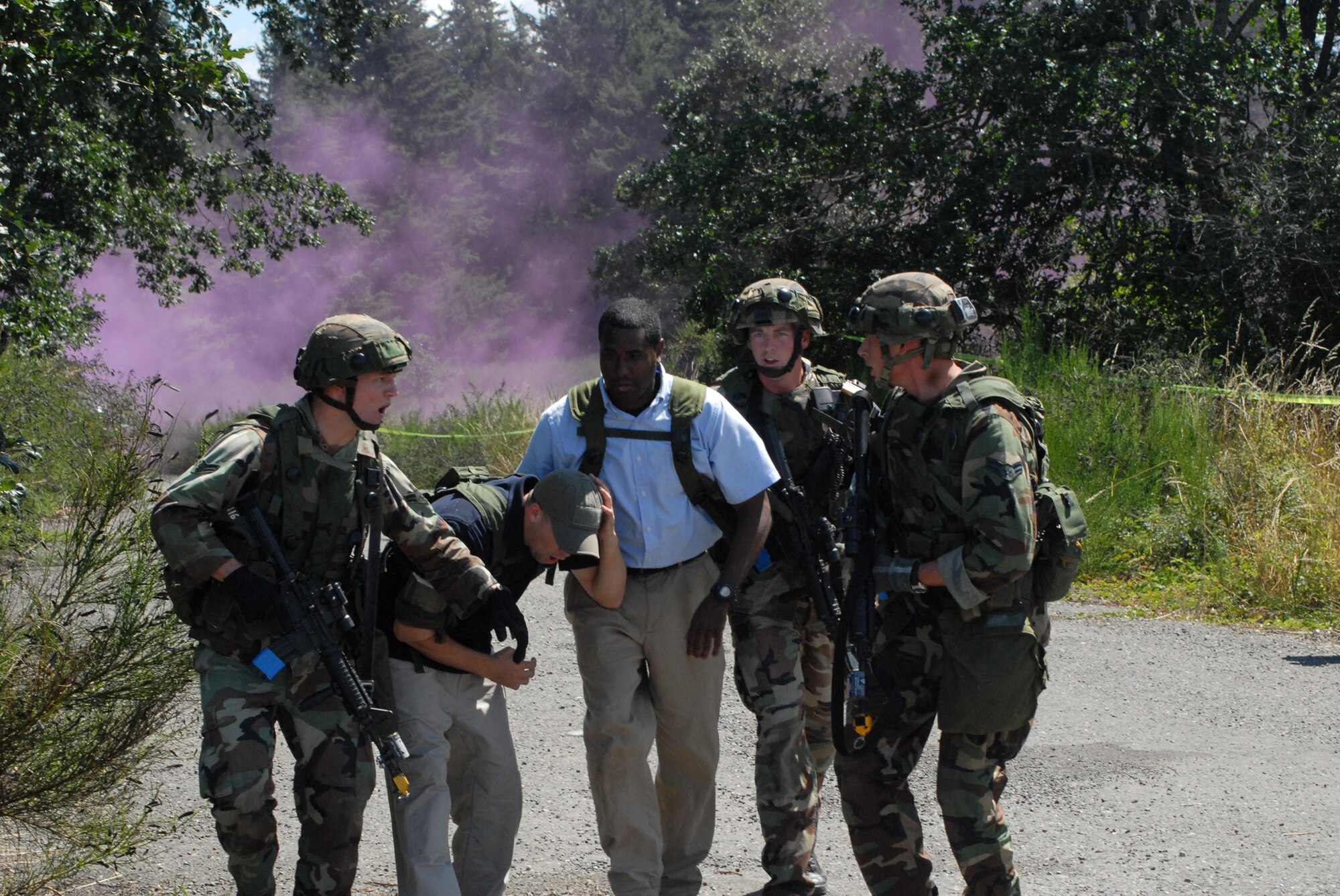 Airman 1st Class David Heilman, Staff Sgt. Mark Mays and Airman 1st Class Matthew Staso, 2007 Pope Rodeo security forces team members, safeguard two members delivering medical supplies on a humanitarian mission during a combat tactics event at McChord AFB, Wash. Tuesday. The three person team also secured a tent during the transfer of medical supplies and engaged combatants while retreating back to their aircraft. (U.S. Air Force photo/Staff Sgt. Jon LaDue)