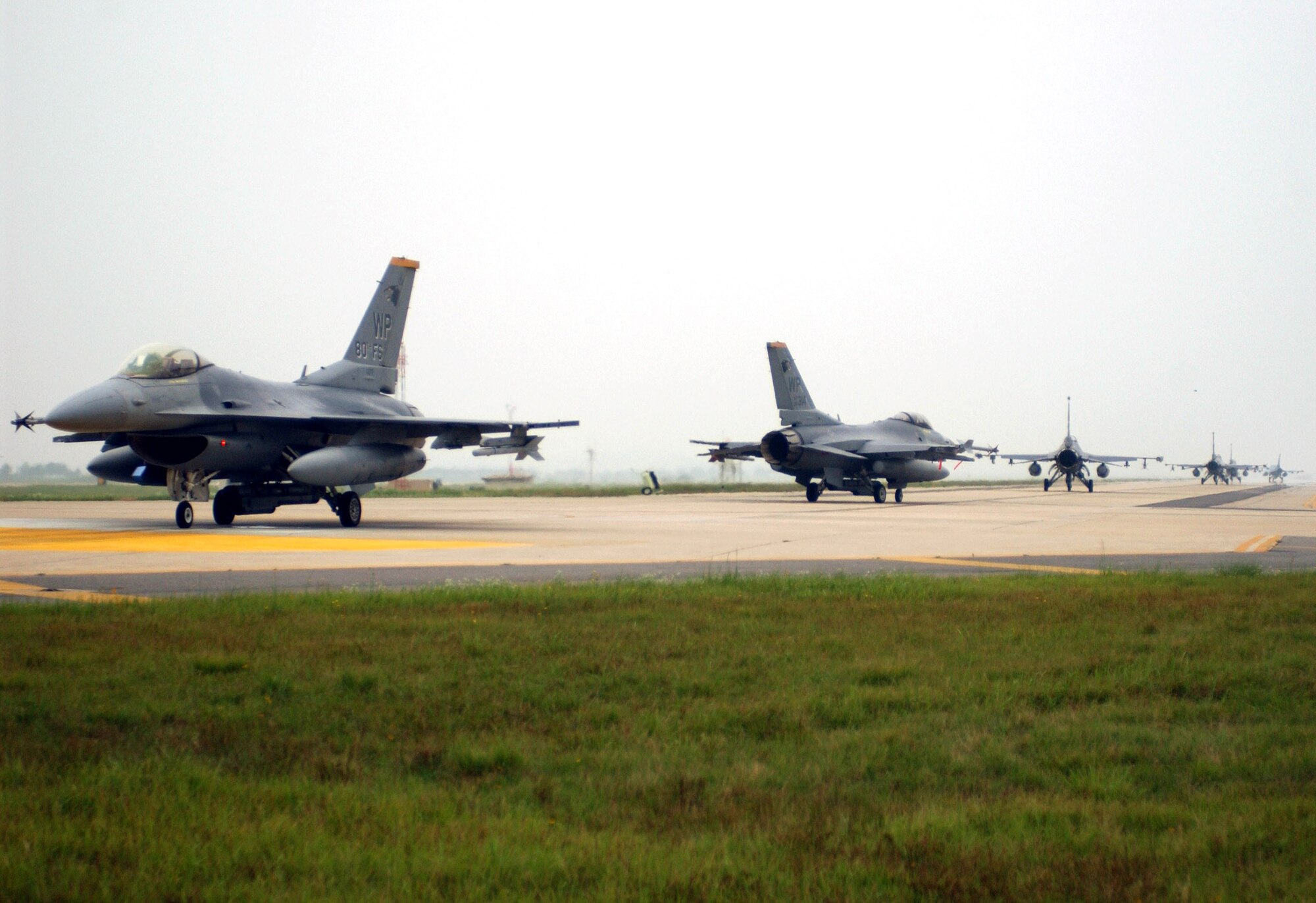 F-16 Fighting Falcons taxi down the runway after returning from a training mission during the Peninsula-Wide Combat Employment Response Exercise July 26 at Kunsan Air Base, South Korea. Members of the 555th Fighter Squadron from Aviano AB, Italy, on their four-month deployment to Kunsan AB teamed up with Airmen of the 8th Fighter Wing. The F-16s are assigned to the 35th, 80th Fighter Squadrons from Kunsan AB, and the 555th FS. (U.S. Air Force photo/Senior Airman Steven R. Doty) 
