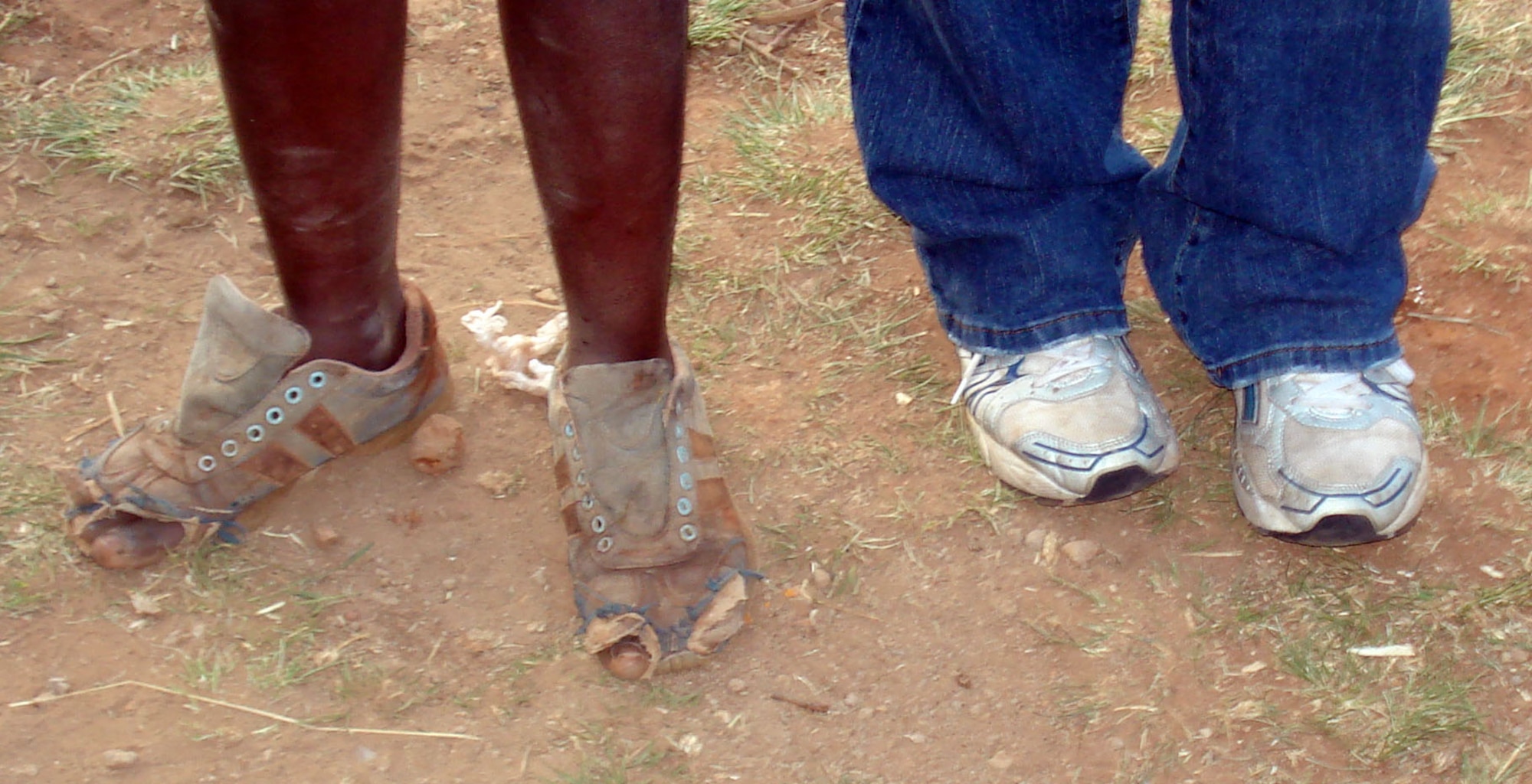 Shoes that were too small, dirty and torn were a common sight on the feet of the children in the village. One of the troops (right) stands beside a village member to show the difference between their footwear.