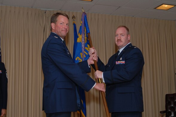 Col. Bradley Herremans, 341st Medical Group commander, passes the 341st Medical Support Squadron guidon to Lt. Col. Duane Bragg at an assumption of command ceremony Monday at the Grizzly Bend Club.  (U.S. Air Force photo / John Turner)