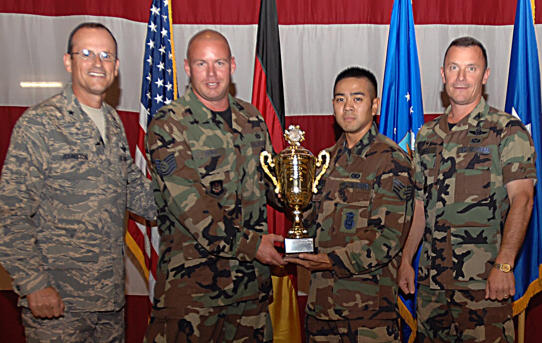 Brig. Gen. Rich Johnston, KMC and 86th Airlift Wing commander, passes the 86th AW Commander's Cup to the 86th Contingency Response Group for winning the Commander's Cup Challenge July 20 during the 86th AW commander's call.


